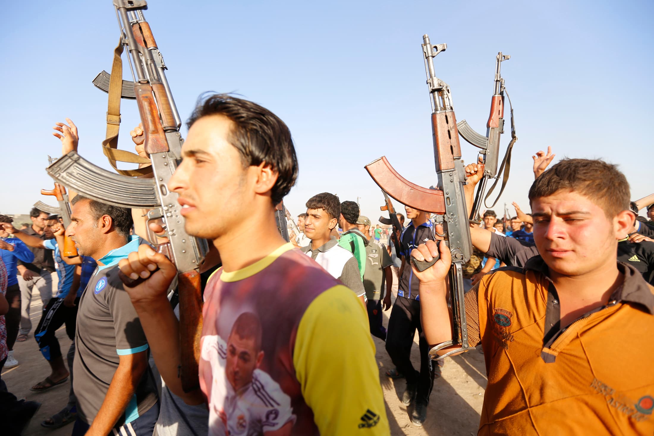 Volunteers who have joined the Iraqi Army to fight against predominantly Sunni militants carry weapons during a parade in the streets in Al-Fdhiliya district, eastern Baghdad.