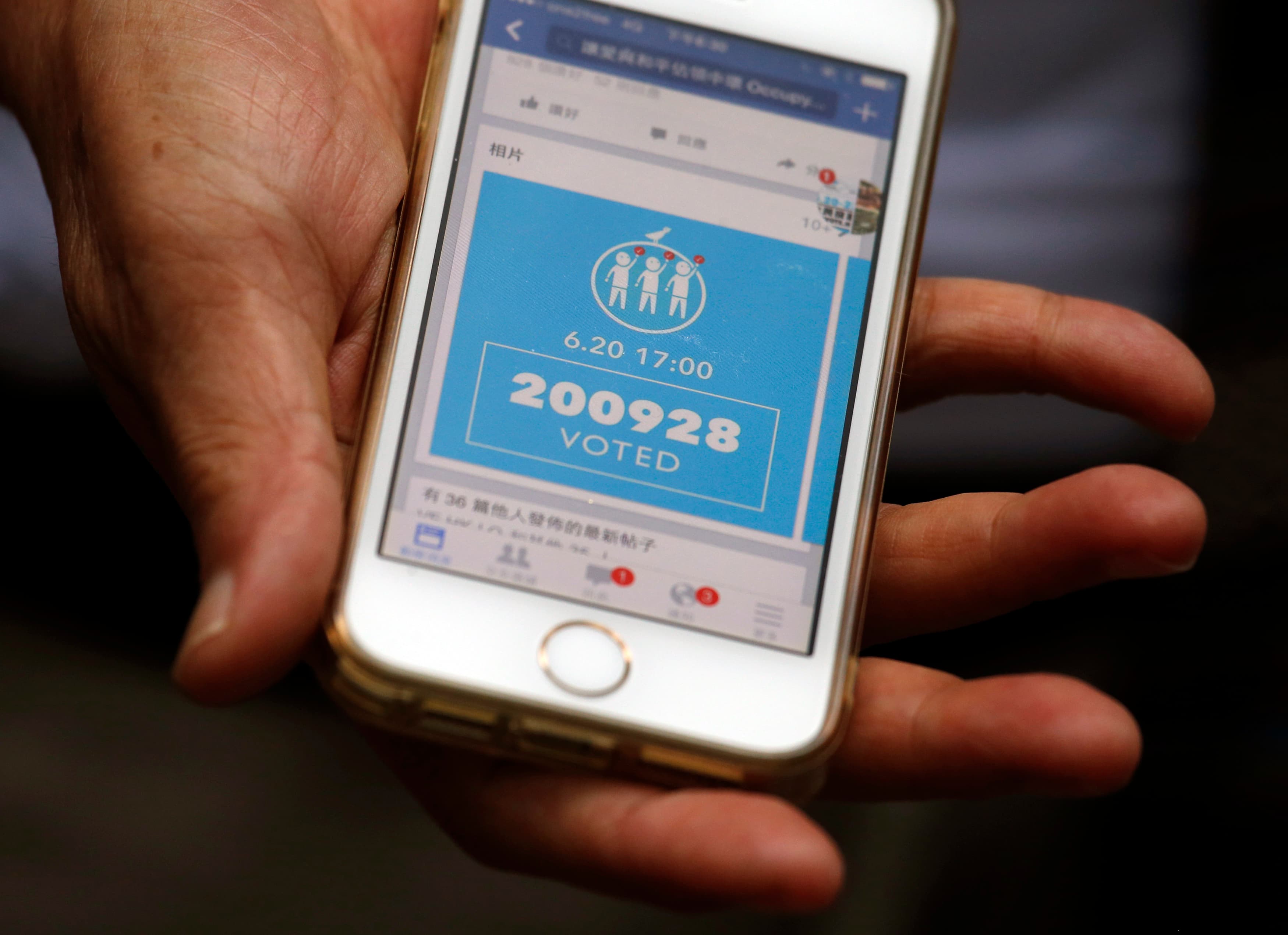 A Hong Kong resident shows a Facebook page announcing the number of votes in the city's unofficial pro-democracy referendum. Many Hong Kongers believe Beijing is trying to undermine the vote with internet attacks.