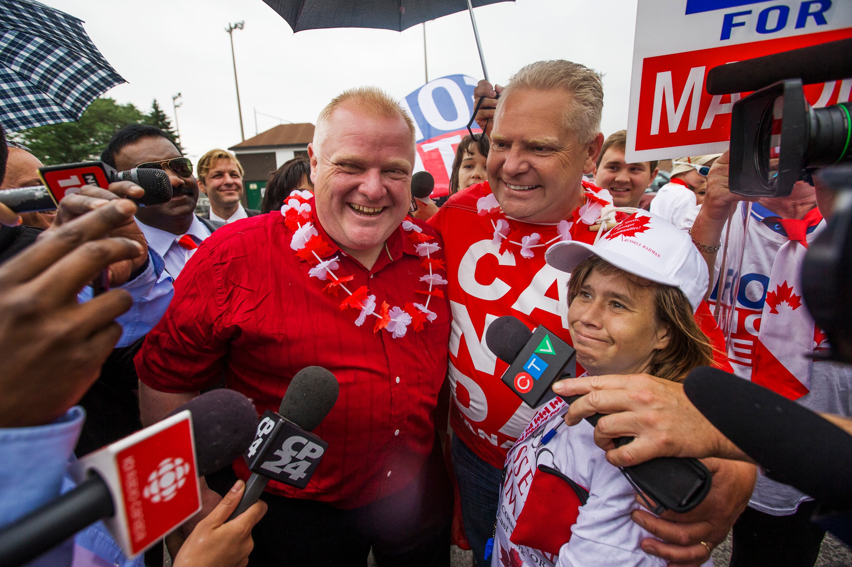 Toronto Mayor Rob Ford (C) and his brother Doug (2nd R) smile as they take part in the East York Canada Day Parade, July 1, 2014.