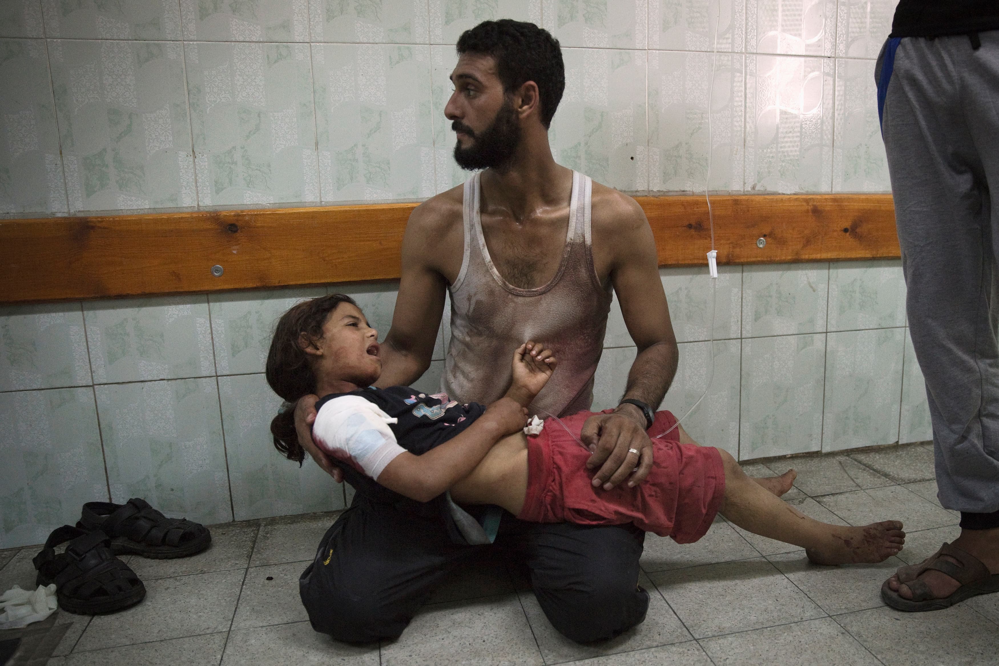 A Palestinian man holds a girl at a hospital in the northern Gaza Strip. Medics said she was injured in shelling at a U.N-run school sheltering Palestinian refugees on July 24, 2014.