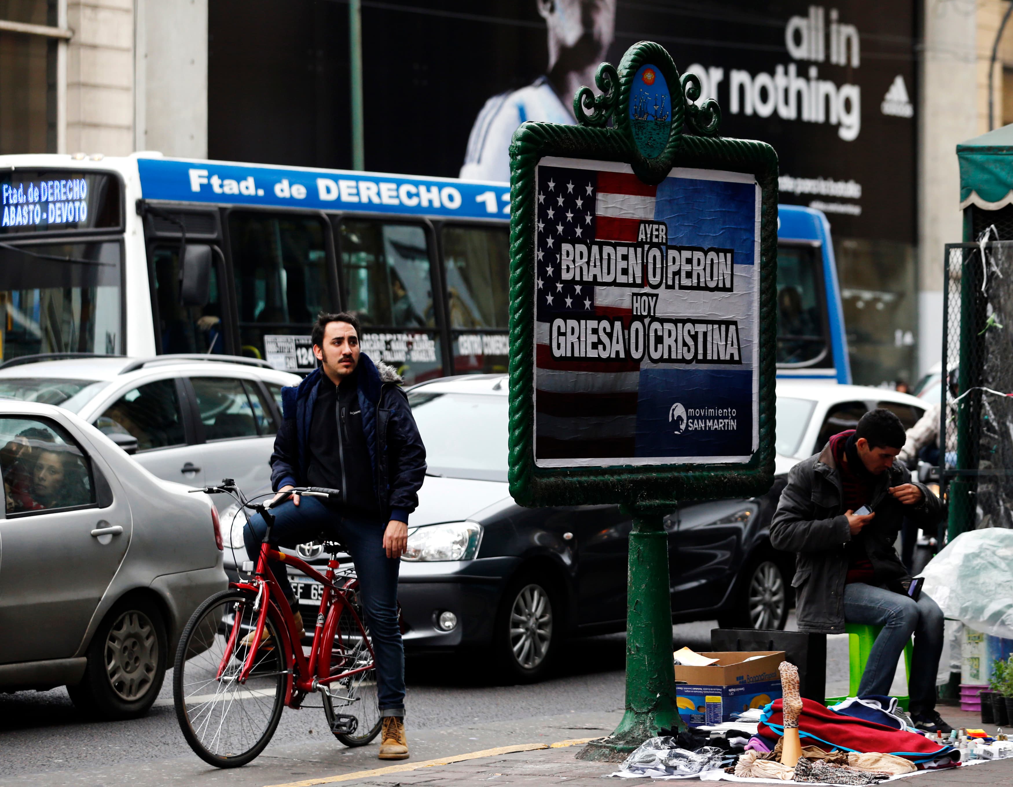 A man looks at a poster placed on an advertising board that reads "Yesterday, Braden or Peron - Today: Griesa or Cristina", in Buenos Aires on July 29, 2014. Argentine debt negotiators held talks in New York on Tuesday with the U.S. mediator in the South