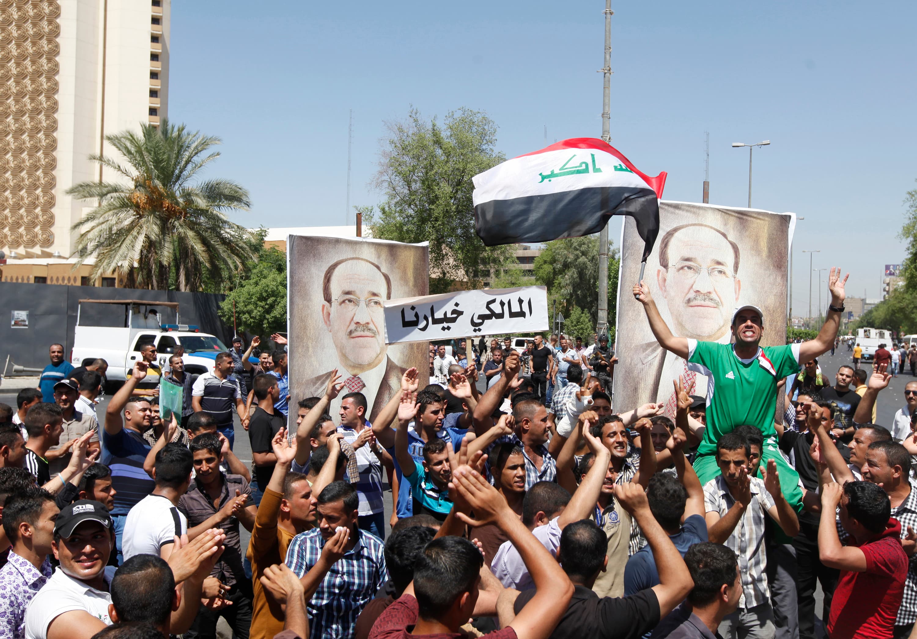 People with portraits of Iraqi Prime Minister Nouri al-Maliki rally in support of him in Baghdad on August 11, 2014.