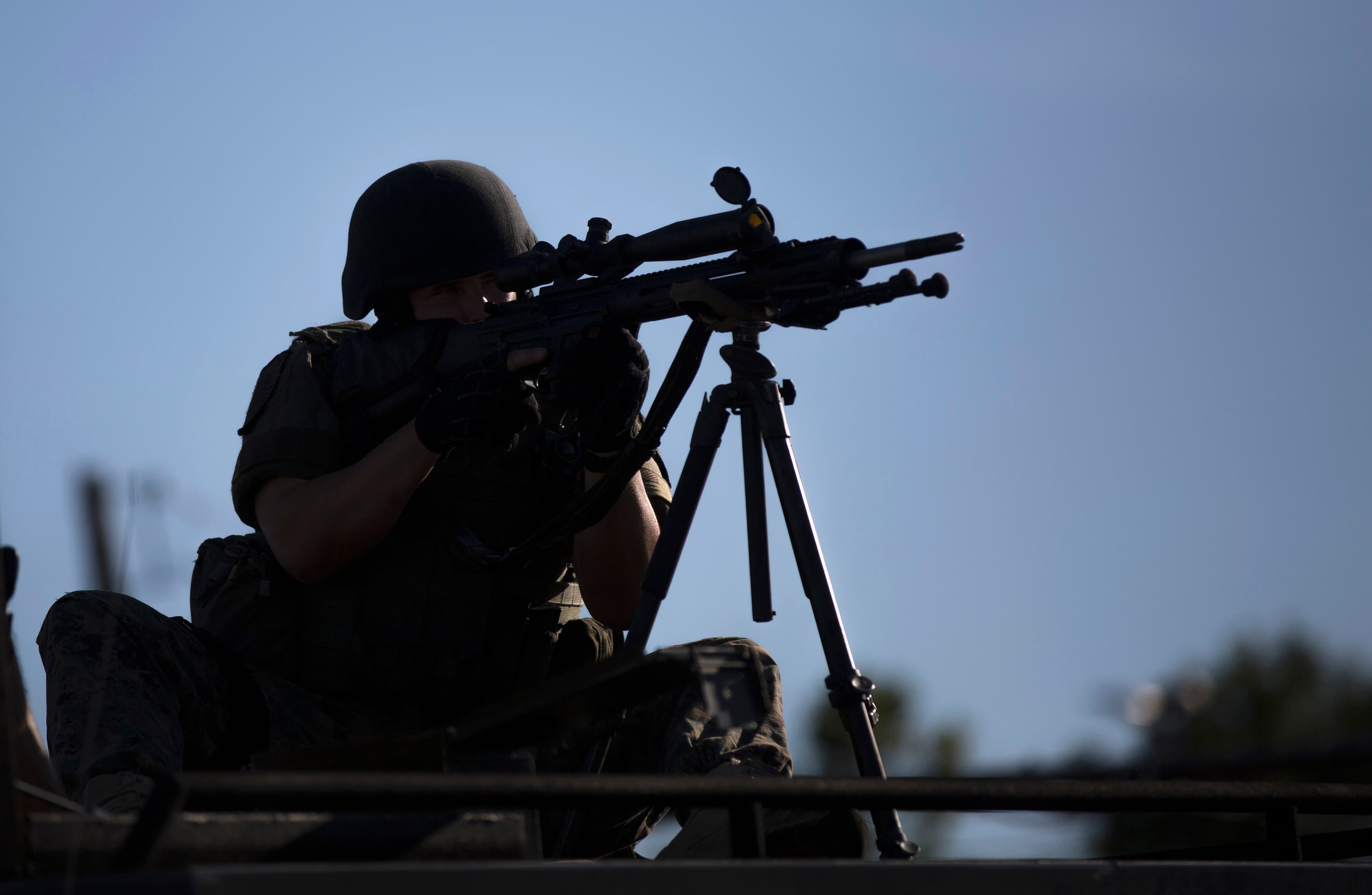 A police officer aims his weapon while demonstrators protest the shooting death of teenager Michael Brown, in Ferguson, on Wednesday.