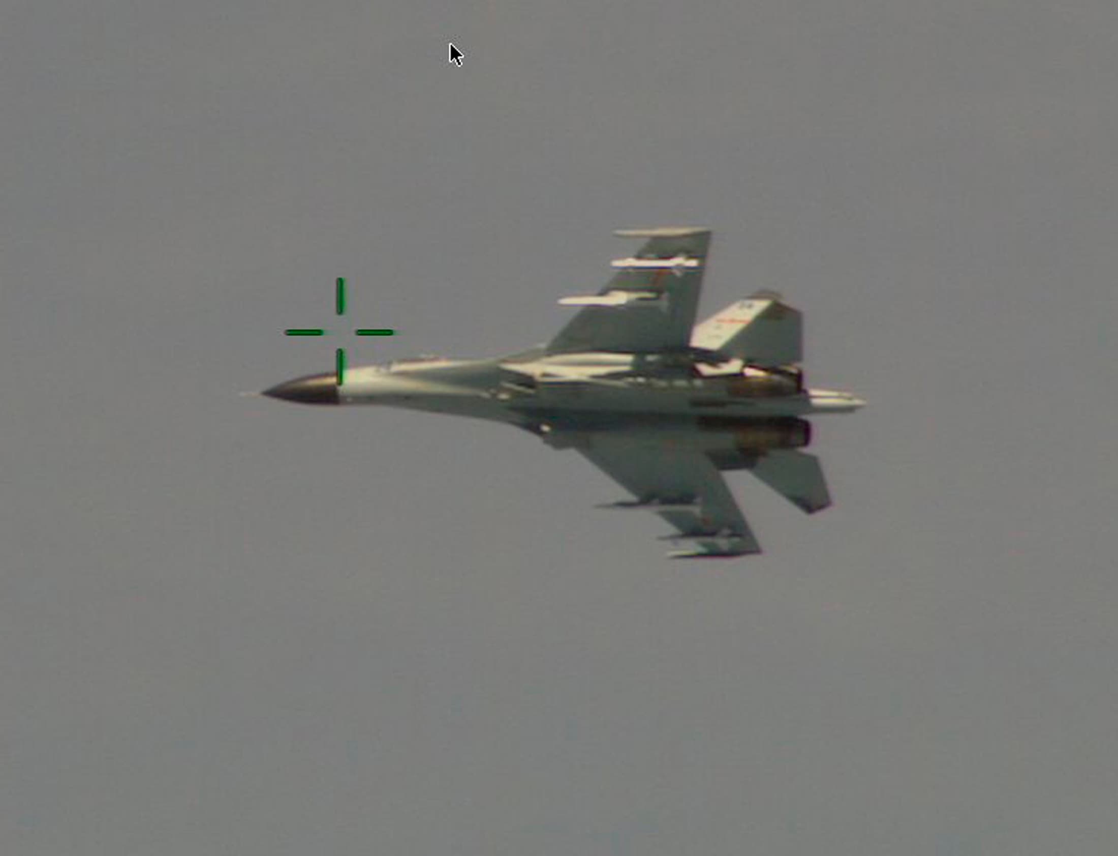 A Chinese J-11 fighter jet is seen flying near a U.S. Navy P-8 Poseidon about 215 km (135 miles) east of China's Hainan Island in this U.S. Department of Defense handout photo taken August 19, 2014.