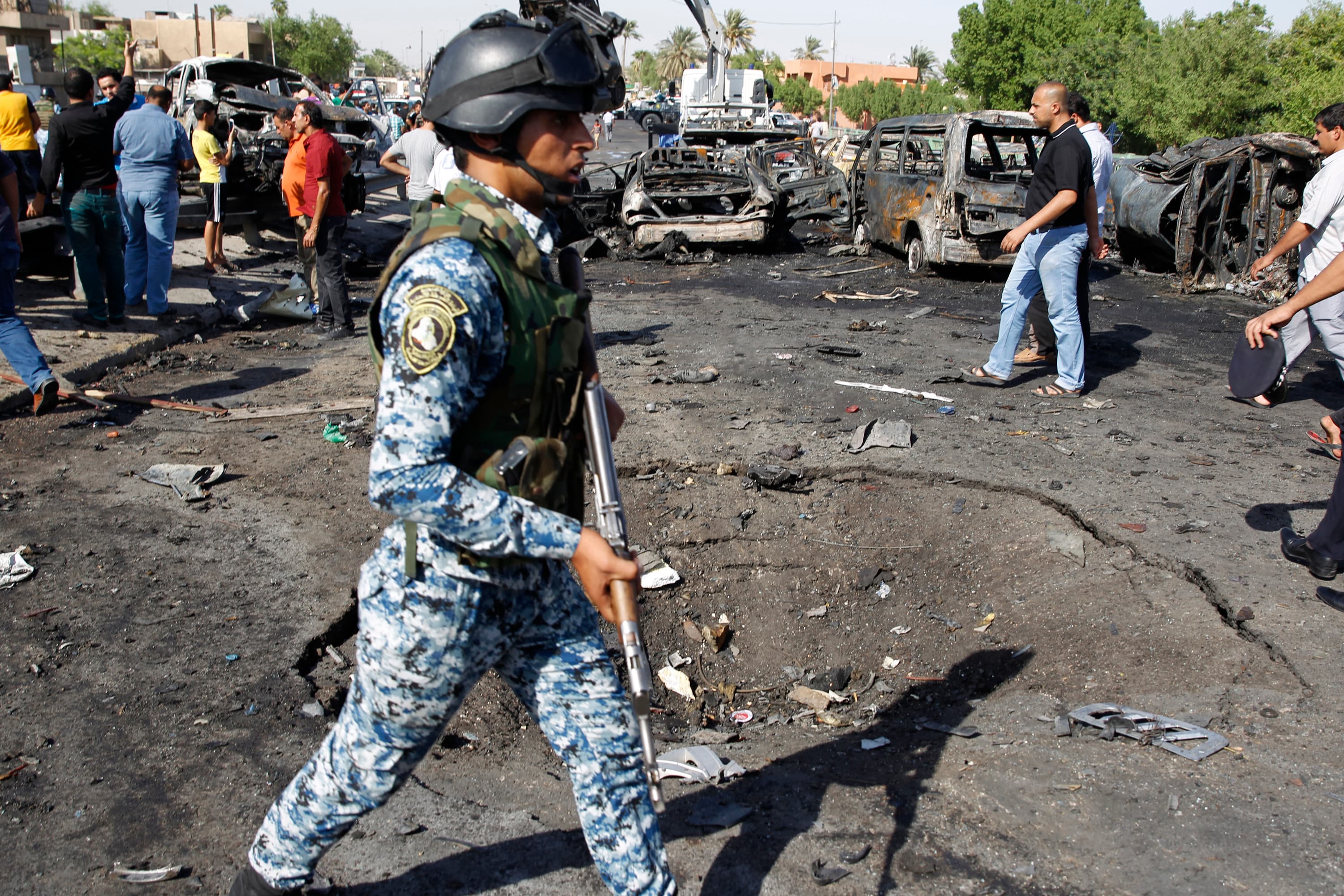 Iraqi security forces inspect the site of three explosions in the New Baghdad neighborhood on September 10, 2014.