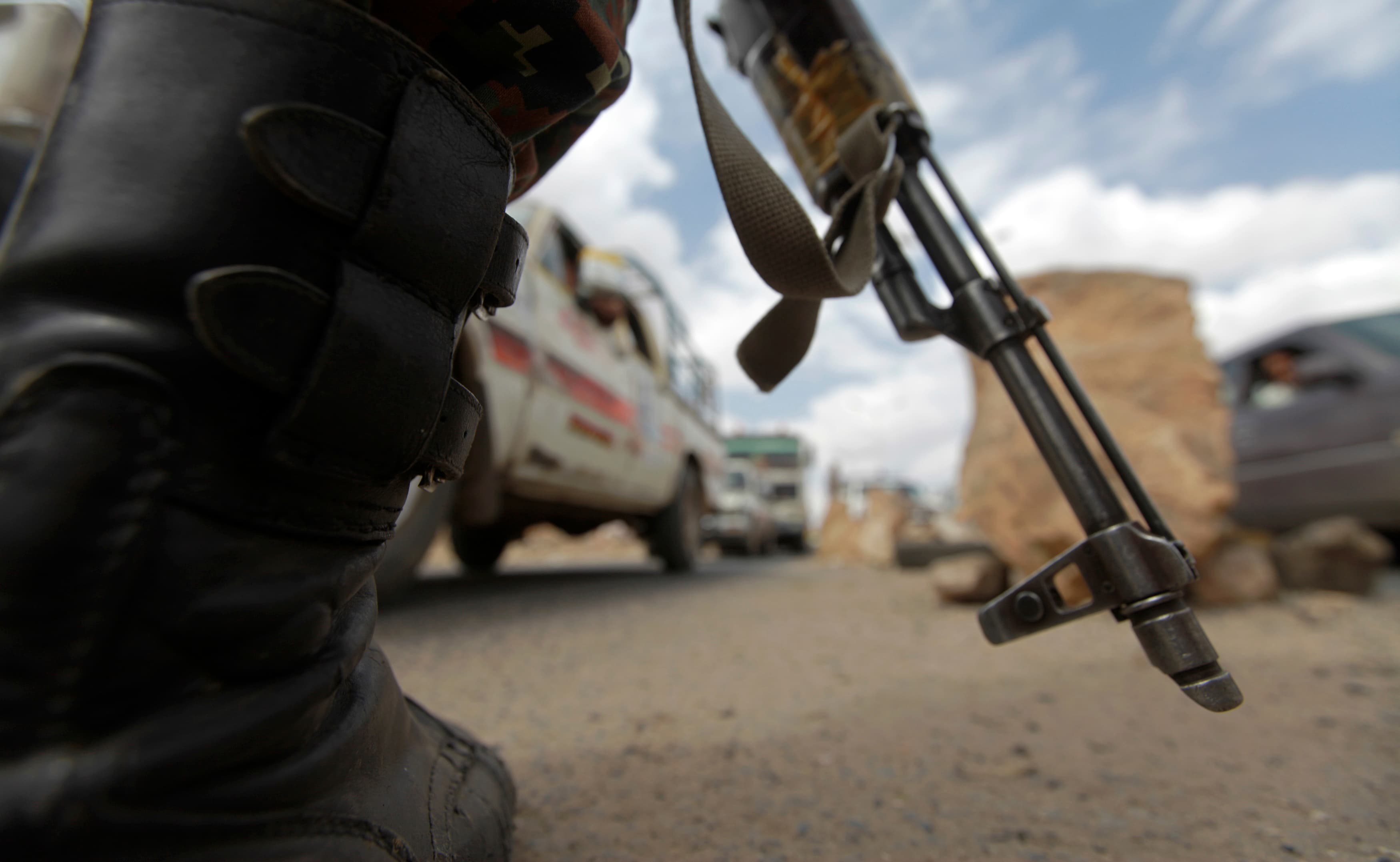 A police trooper stands at a checkpoint in Sanaa, the capital of Yemen, where government forces and Shi'ite Muslim Houthi rebels signed an agreement this week to end a crisis that has seen weeks of sometimes bloody protests.