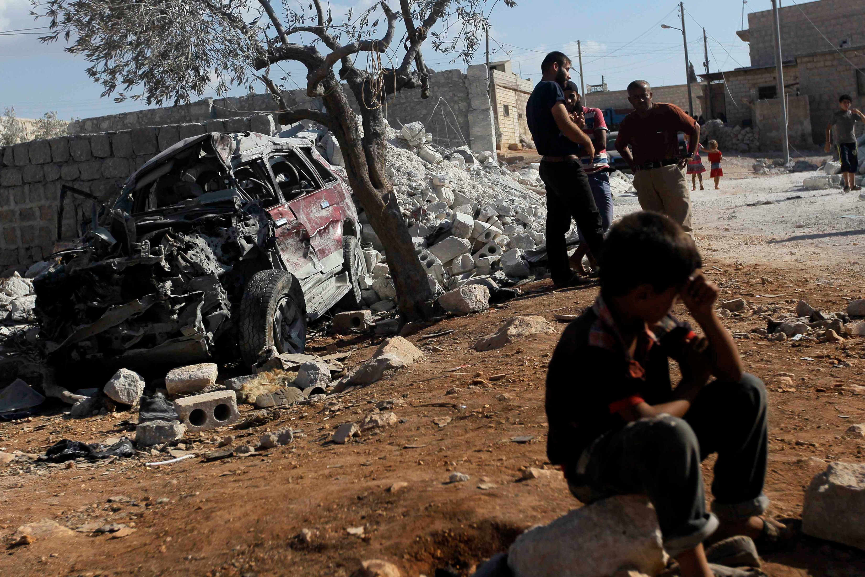 Residents inspect a damaged site in what activists say was a US strike in Kfredrian, Idlib province, Syria, on September 23, 2014.