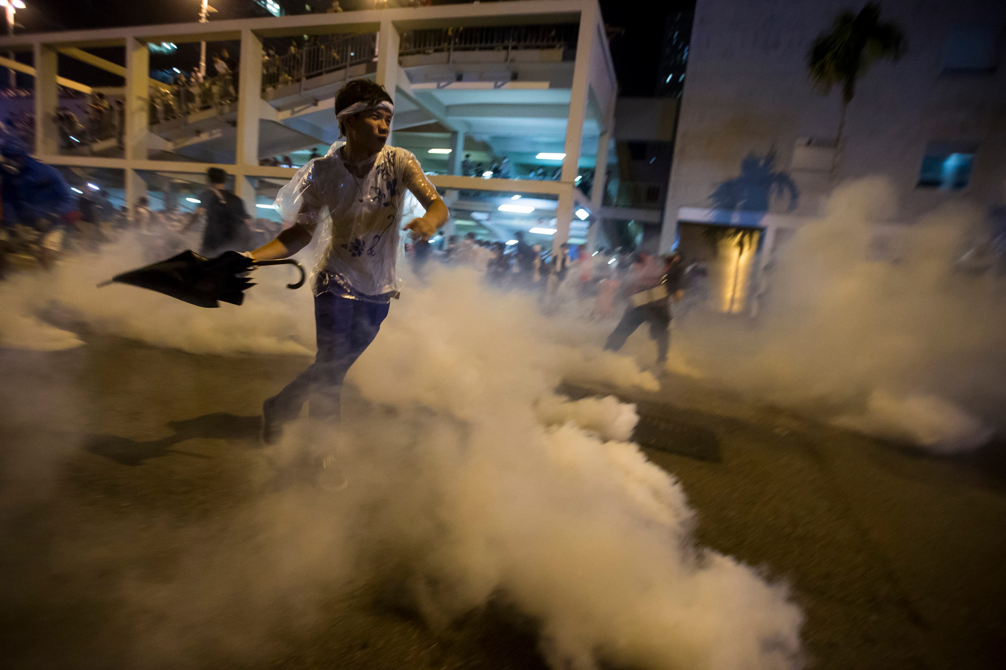 A protester throws an umbrella at riot police as fellow demonstrators blocked the main street to the central financial district outside government headquarters in Hong Kong on September 29, 2014.