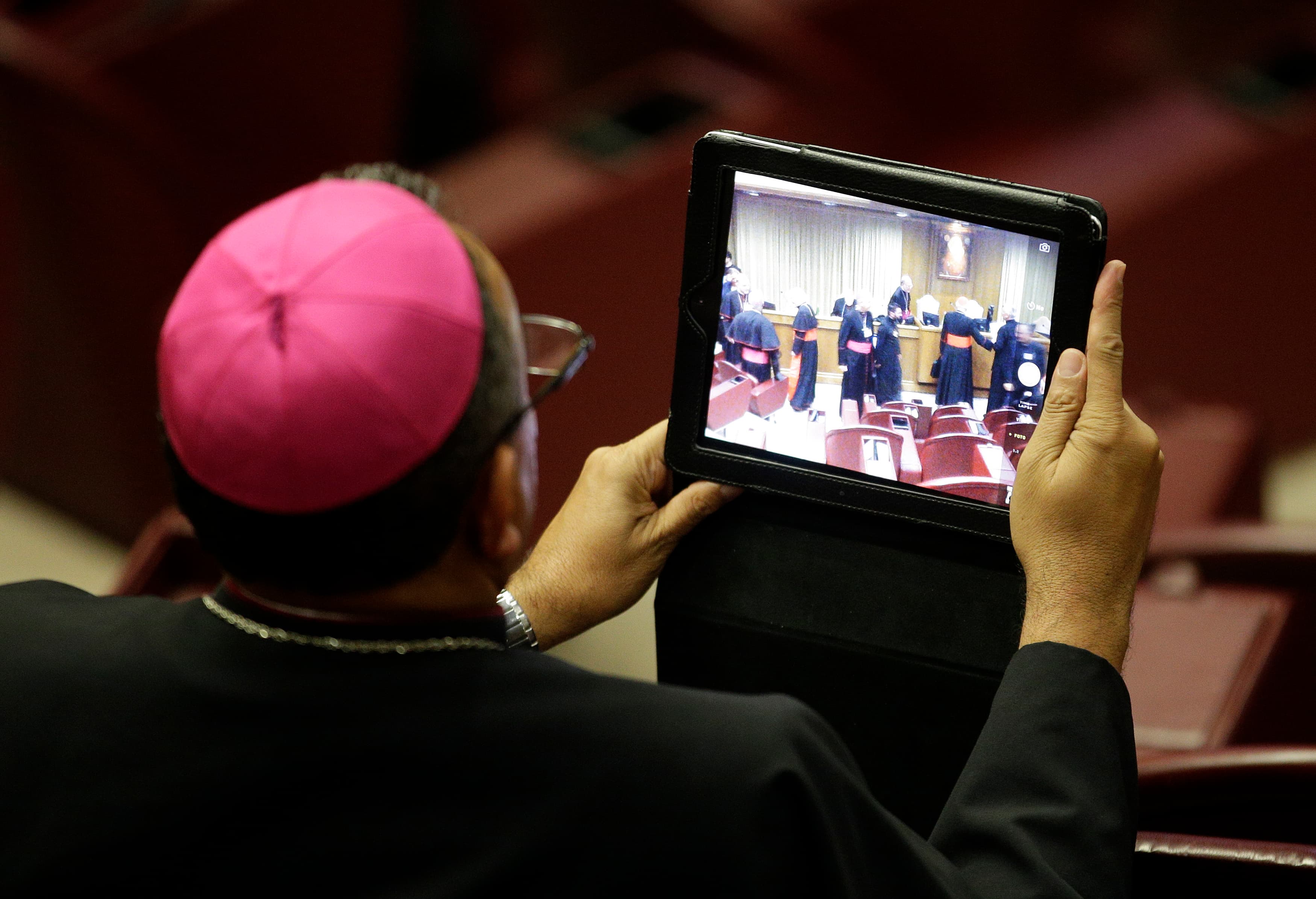 A bishop takes a picture with a tablet during the Synod on the Family. The Roman Catholic assembly has softened its traditional Catholic stance against gays, suggesting "accepting and valuing their sexual orientation."