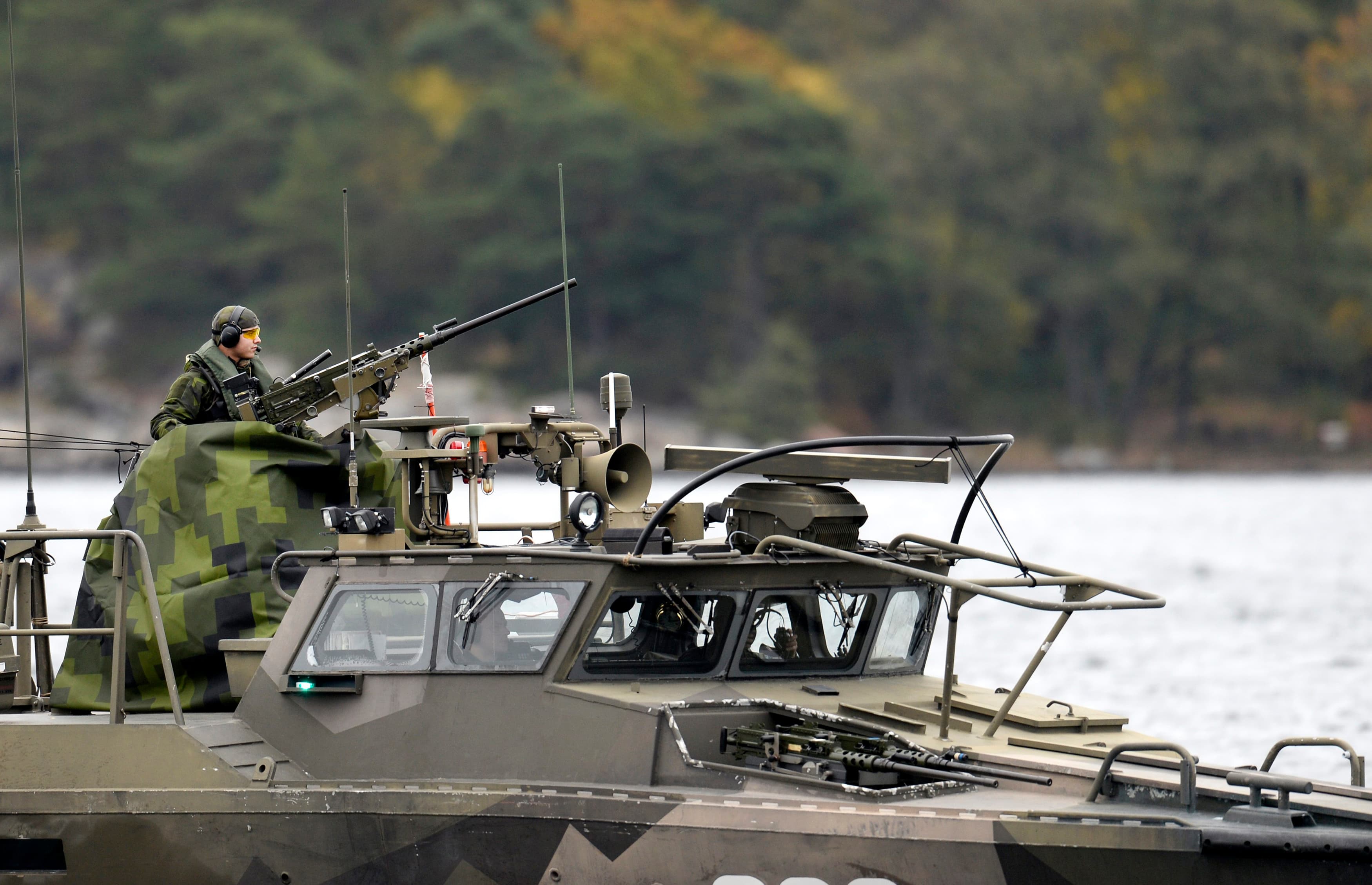 Crew members onboard a Swedish Navy fast-attack craft stand guard at the Stockholm archipelago during a hunt for a suspected Russian submarines on October 18, 2014.