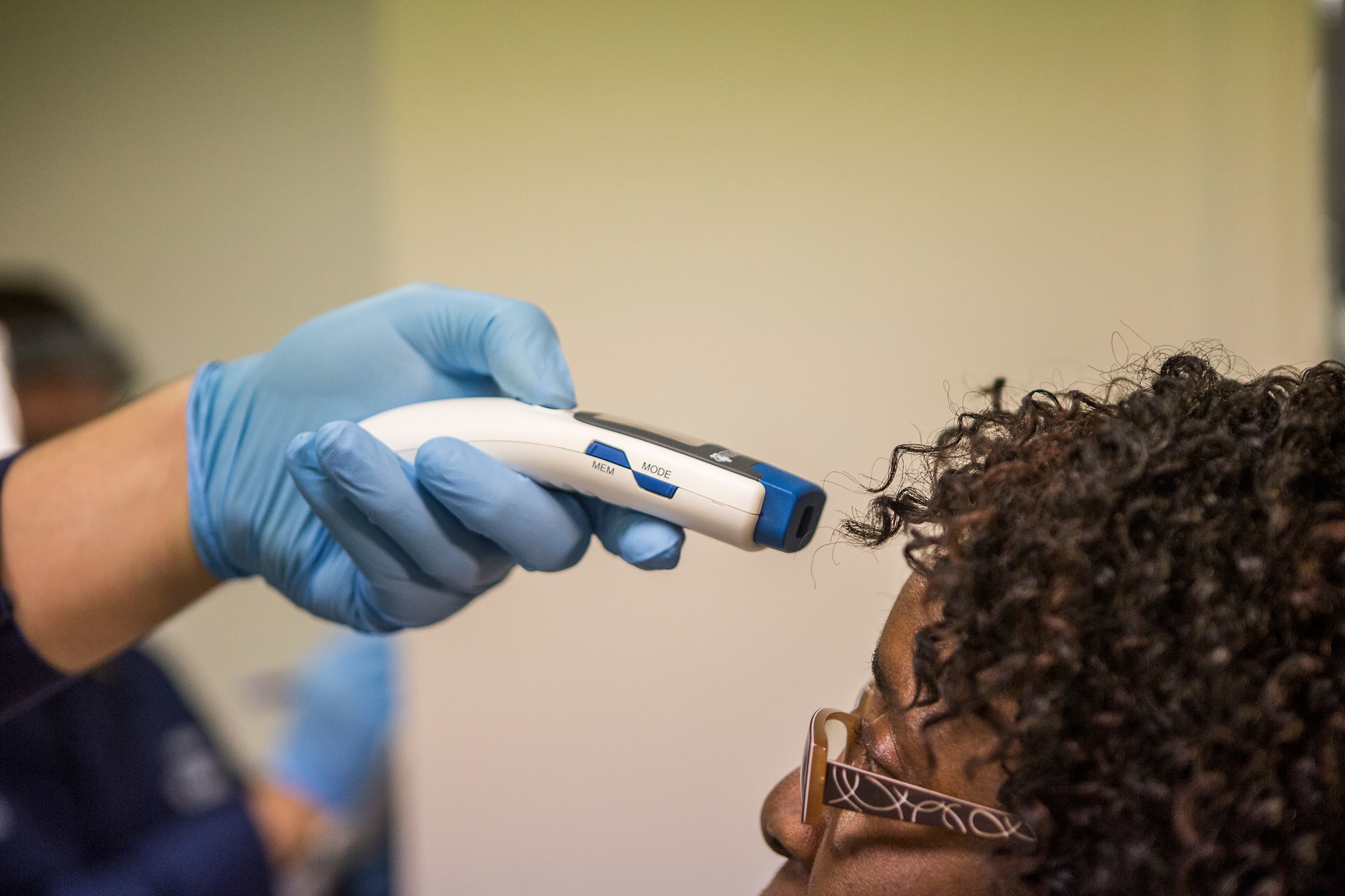 A US Coast Guard corpsman at Washington Dulles International Airport checks the temperature of a traveler from West Africa.