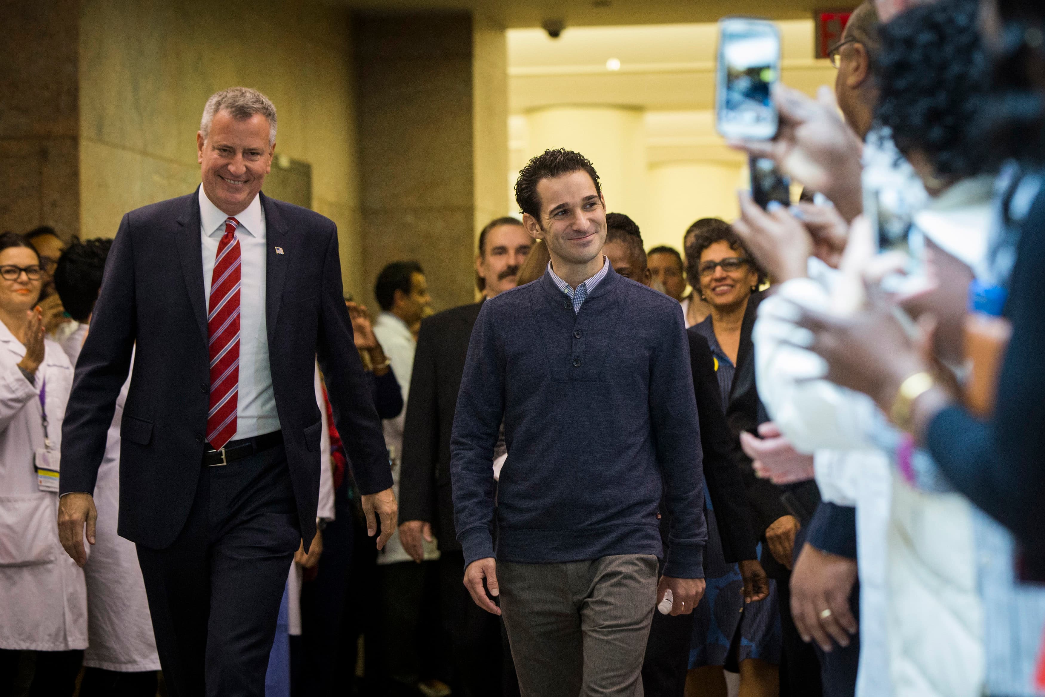 New York Mayor Bill de Blasio walks with Dr. Craig Spencer, at right, as he is discharged from Bellevue Hospital after being declared free of the Ebola virus on November 11, 2014.
