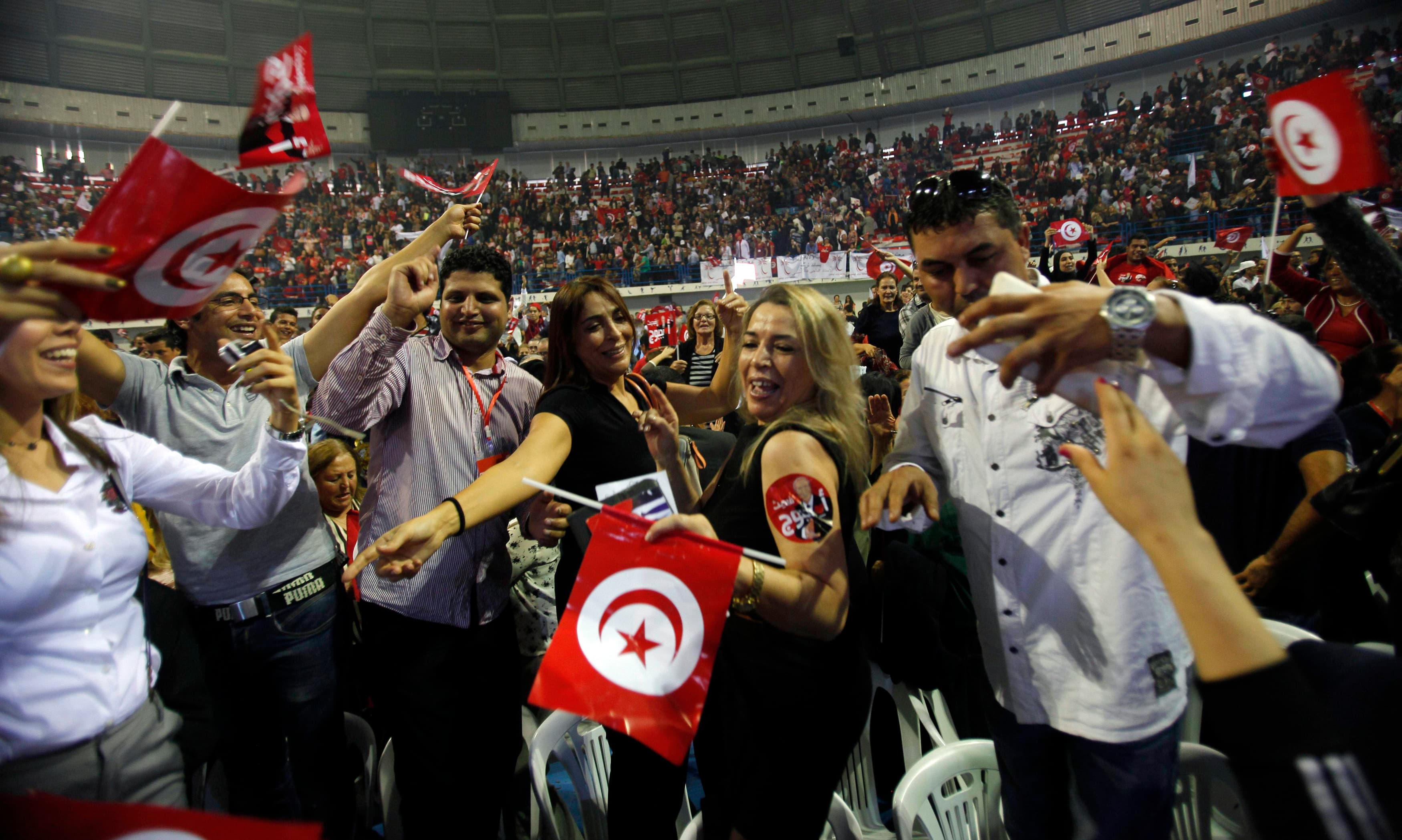 Supporters of Beji Caid Essebsi, the Nidaa Tounes party leader and presidential candidate, wave flags and shout slogans during a presidential electoral campaign rally in Tunis on November 15, 2014.