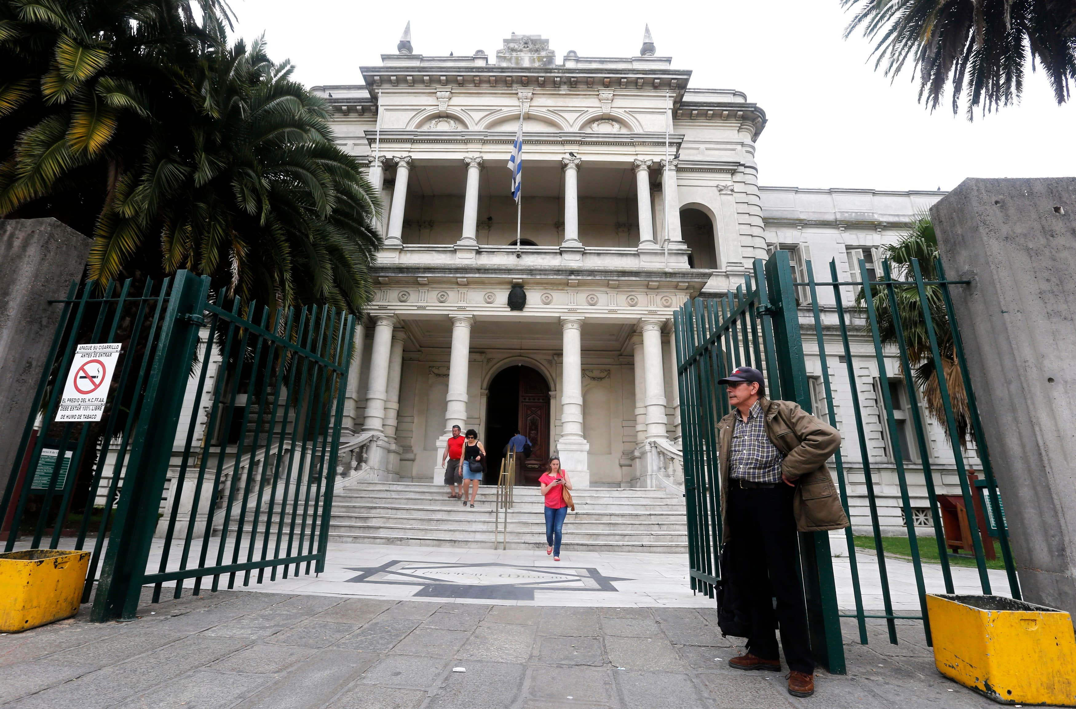 People are seen in front of the Hospital Militar (Military Hospital), where six ex-inmates from Guantanamo Bay are being housed in Montevideo, on December 8, 2014.