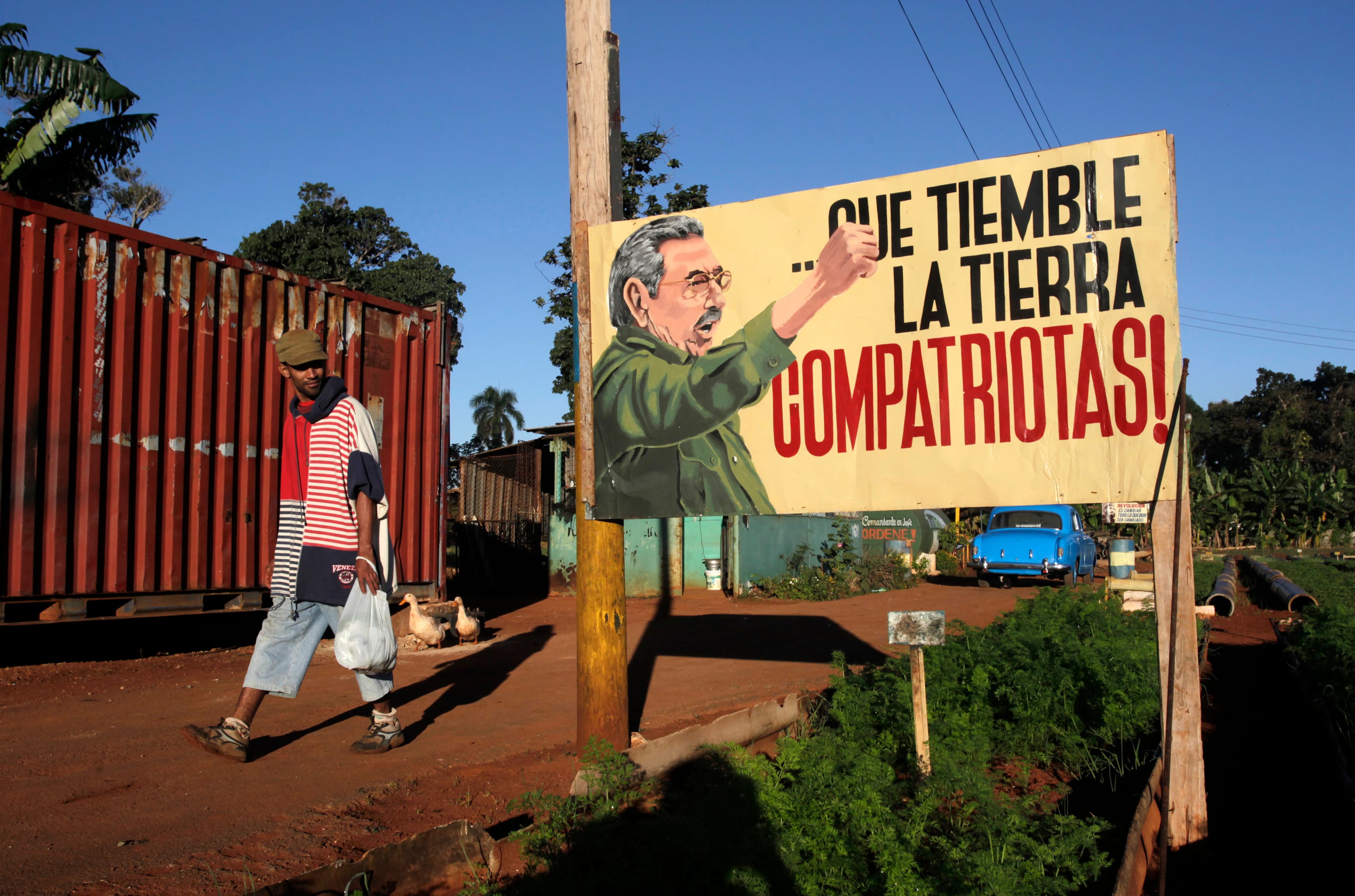 A man walks near a sign with an image of Cuban President Raul Castro in Havana December 19, 2014.