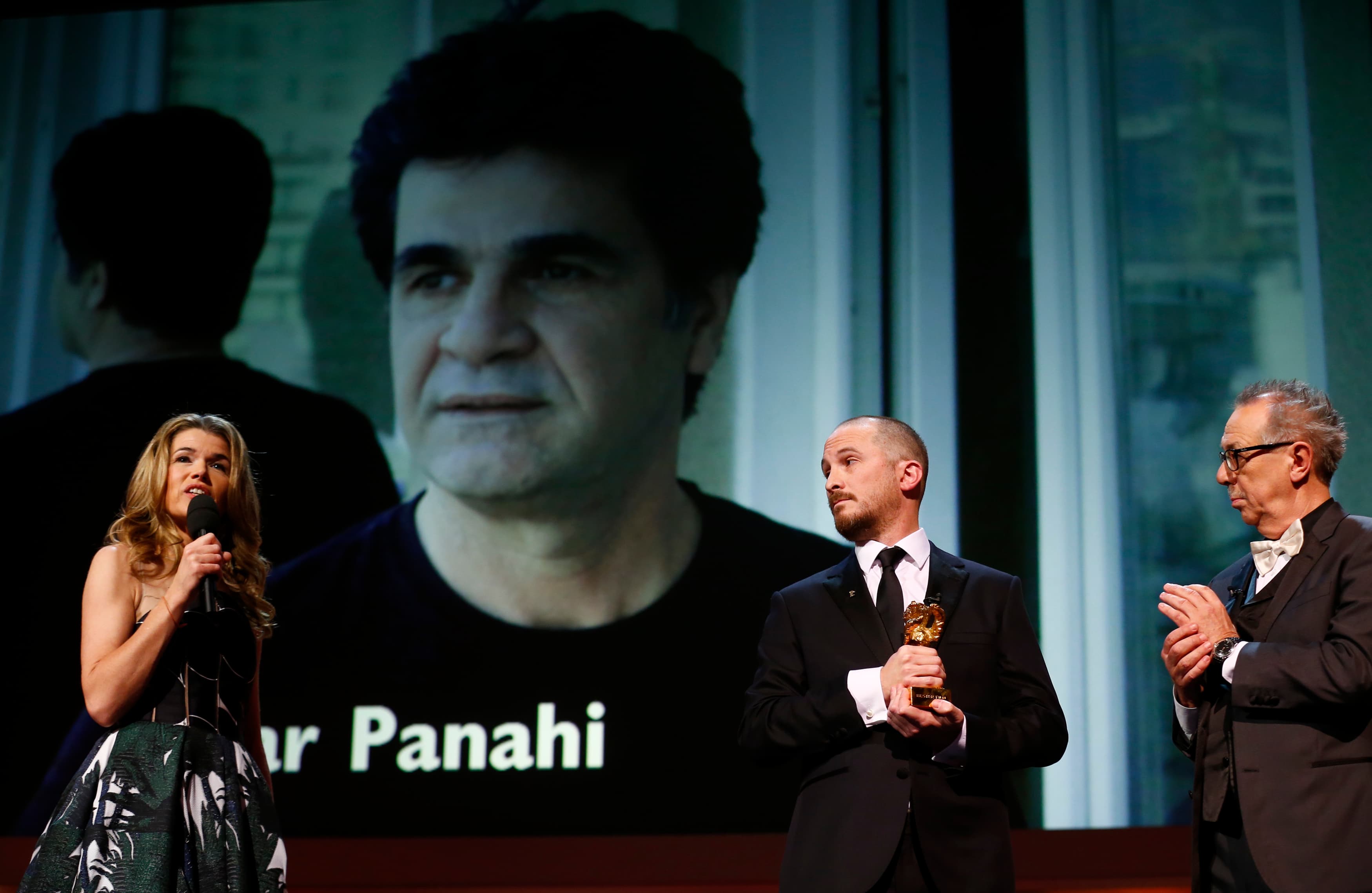 Jury president Darren Aronofsky holds the Golden Bear for Best Film for the film "Taxi" by Jafar Panahi as he stands between presenter Anke Engelke and festival director Dieter Kosslick at the awards ceremony of the 65th Berlinale International Film Festi