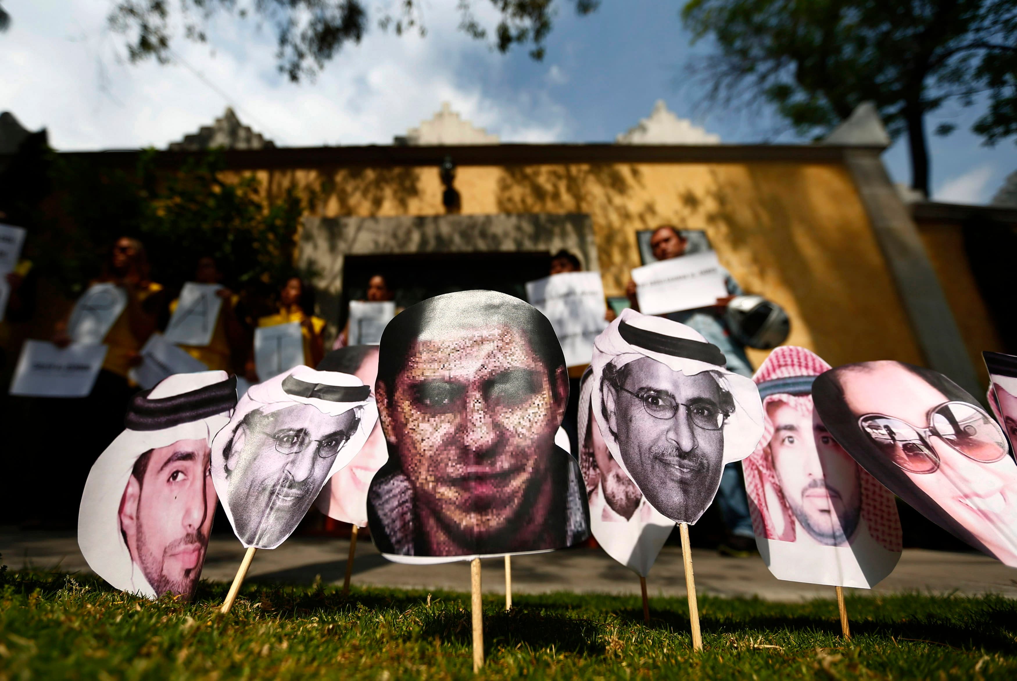 A picture of Saudi blogger Raif Badawi (C) is seen between others photos of prisoners in Saudi Arabia during a demonstration for his release from jail outside the Embassy of Saudi Arabia in Mexico City.