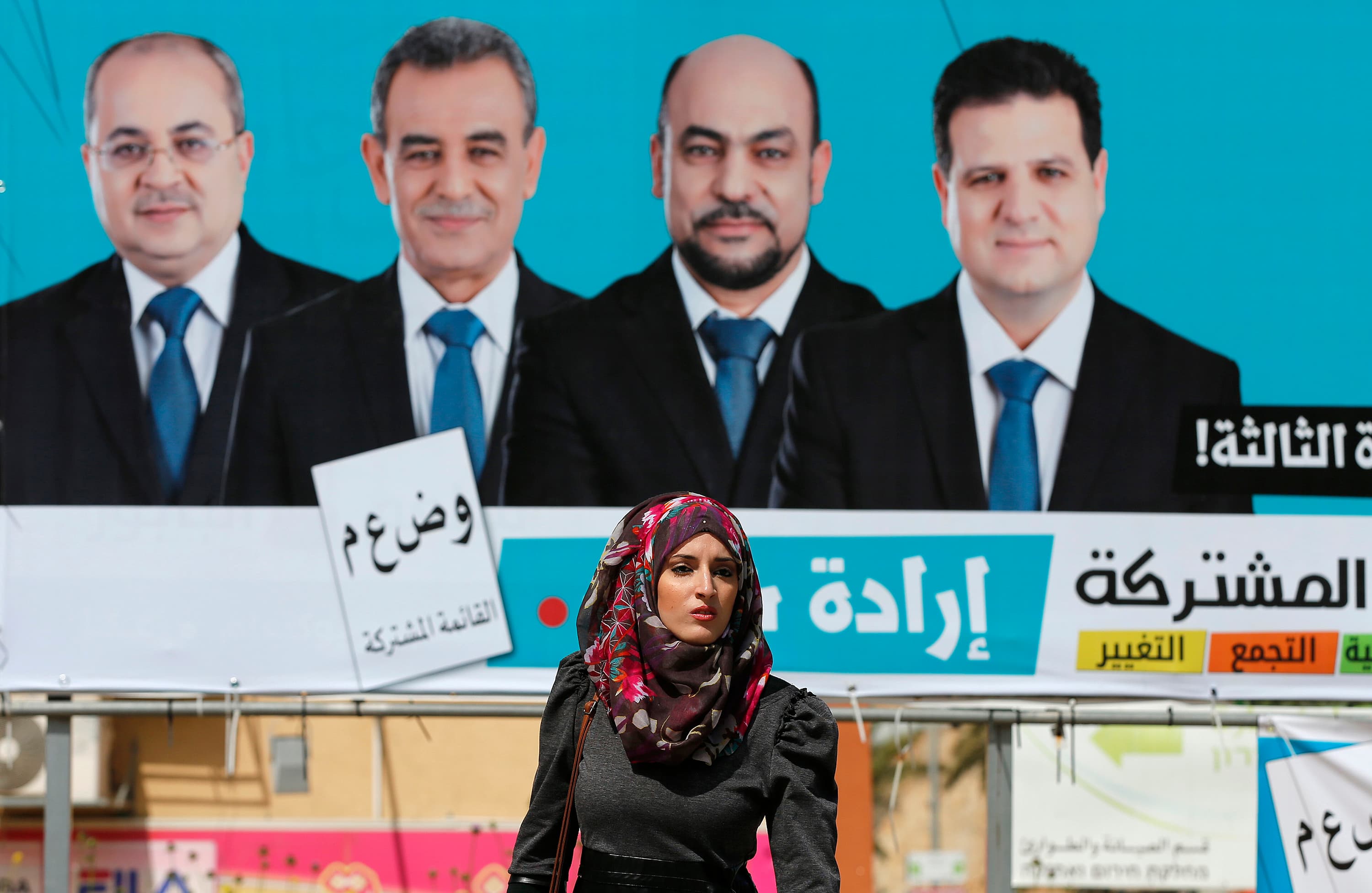 A woman walks past a Joint Arab List campaign billboard. Four Arab-Israeli political parties have united for the first time, making the group the third-largest political faction in the Knesset.