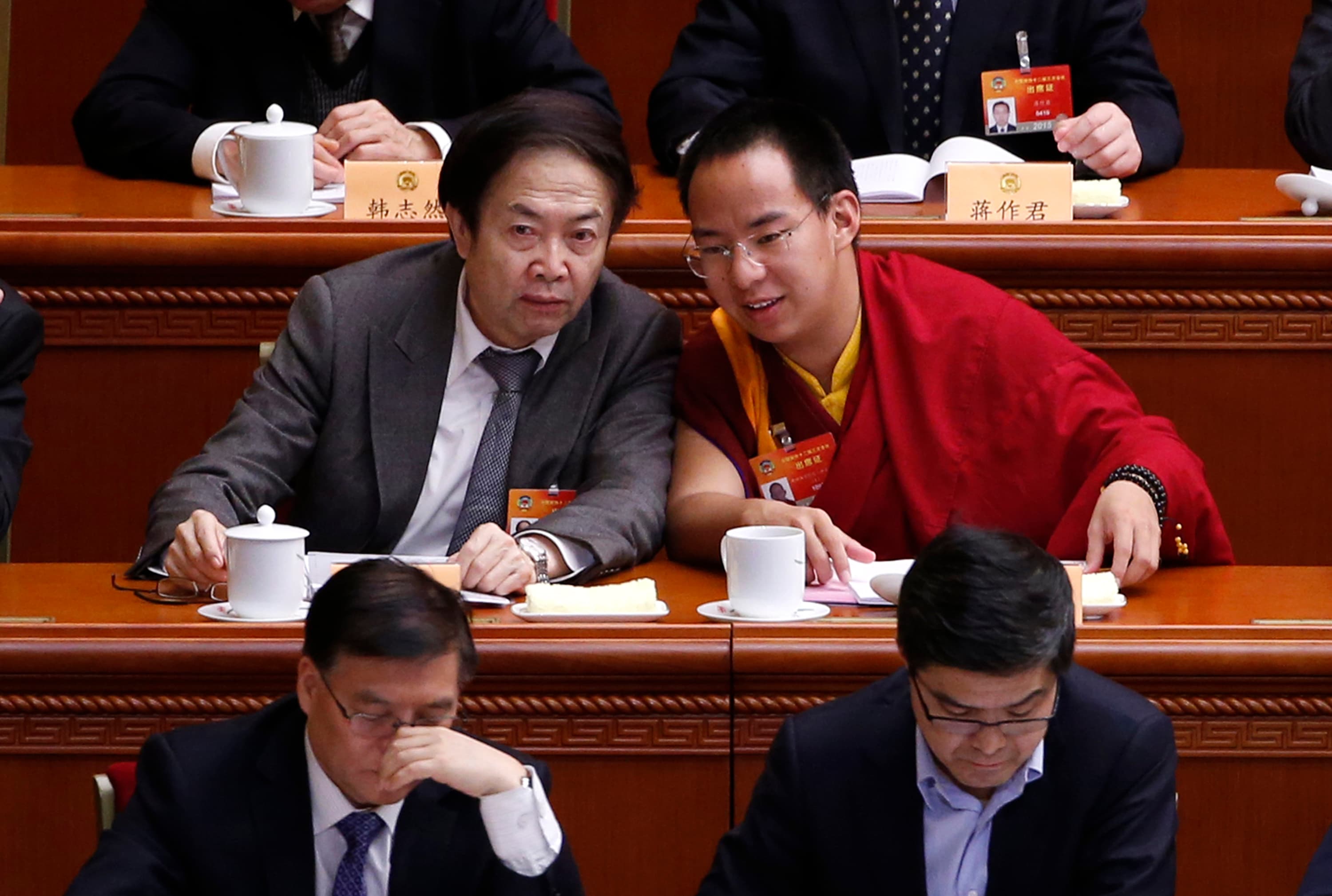Gyaltsen Norbu (R), the 11th Panchen Lama, speaks with a delegate ahead of the opening of the third plenary meeting of Chinese People's Political Consultative Conference (CPPCC) at the Great Hall of the People in Beijing, March 11, 2015.