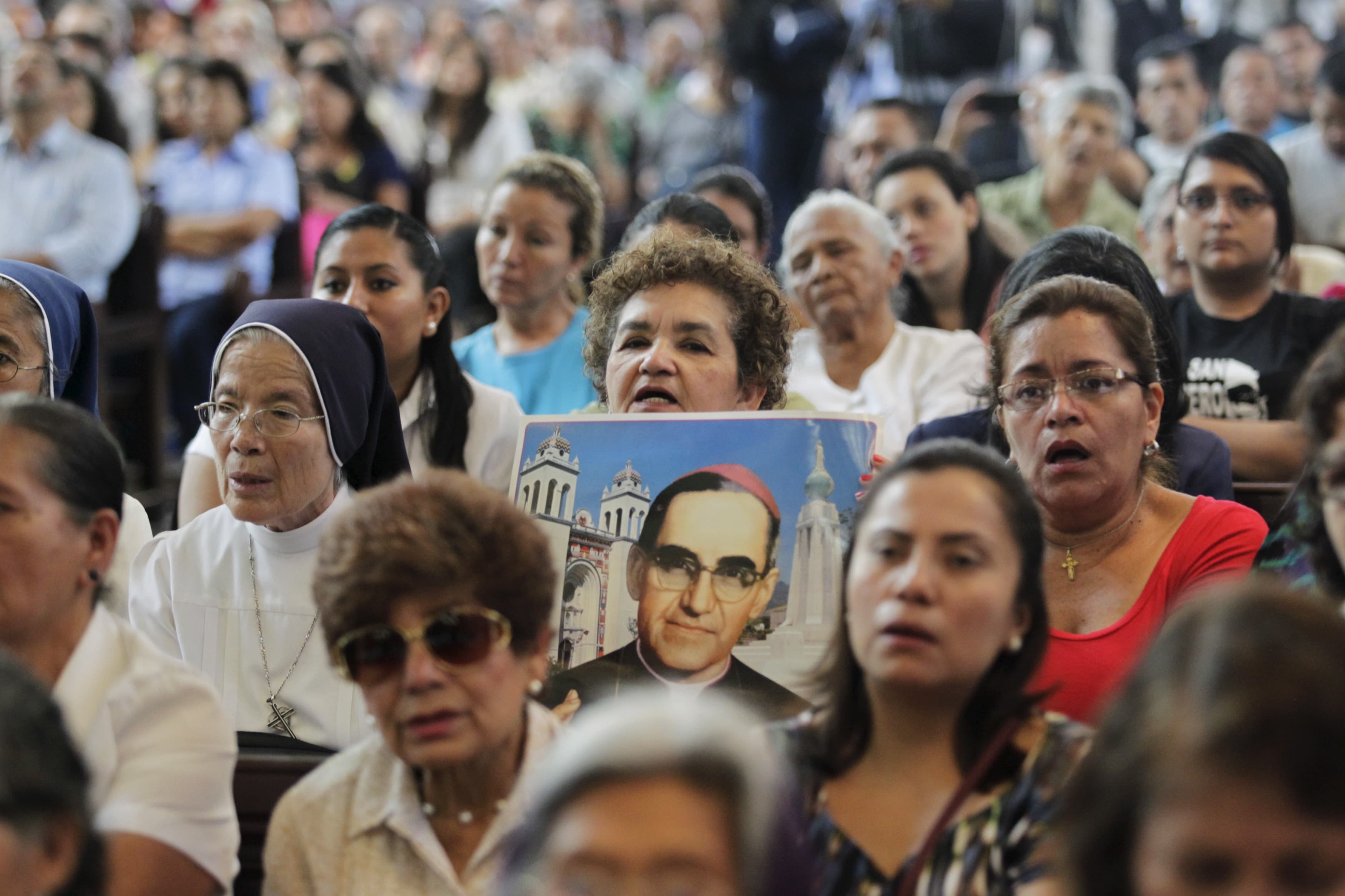 A woman holds a picture of late Archbishop Oscar Arnulfo Romero during a Mass to commemorate the 35th anniversary of his assassination in San Salvador on March 24.