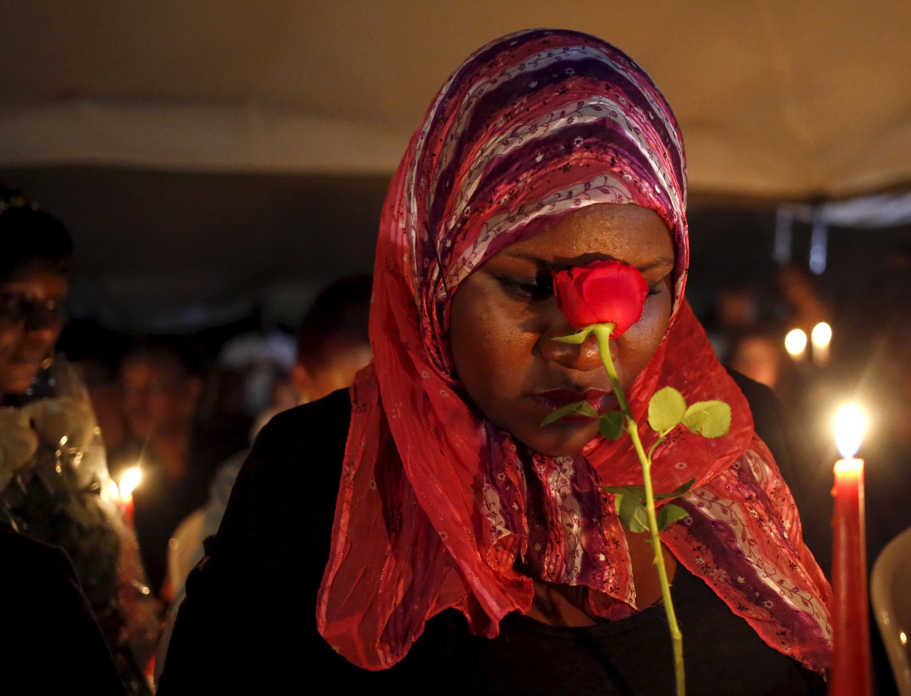 A woman holding a rose prays during a Nairobi memorial vigil following an attack by gunmen at Kenya's Garissa University College.