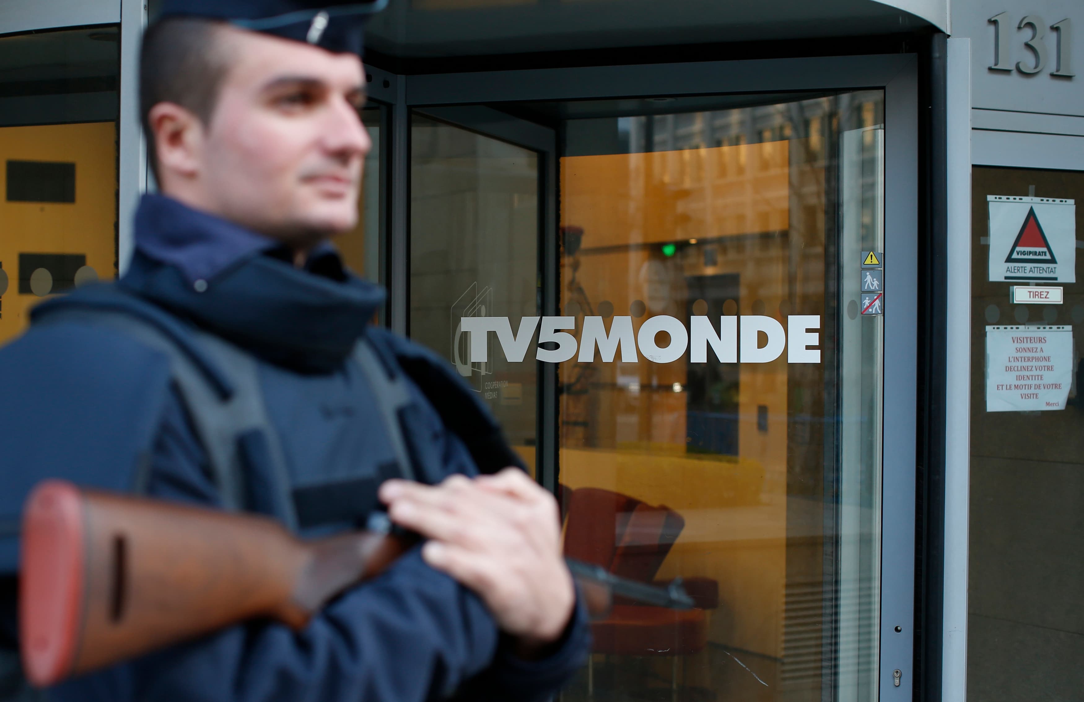 A police officer stands guard in front of the main entrance of French television network. The network is now believed to have been hacked by a Russian group linked to the hackers who have leaked emails from the Hillary Clinton campaign.