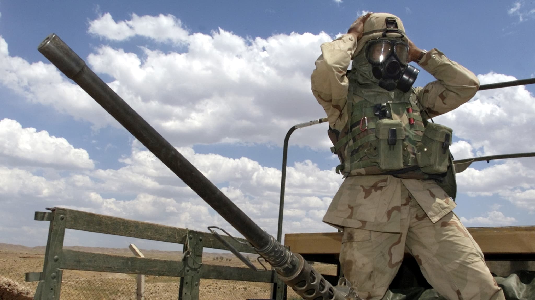 A soldier from the US Army's 173rd Airborne Brigade adjusts his gas mask prior to an air analysis mission near an oil and gas separation plant at the Baba Gurgur oil field outside northern Iraq's town of Kirkuk on May 3, 2003.