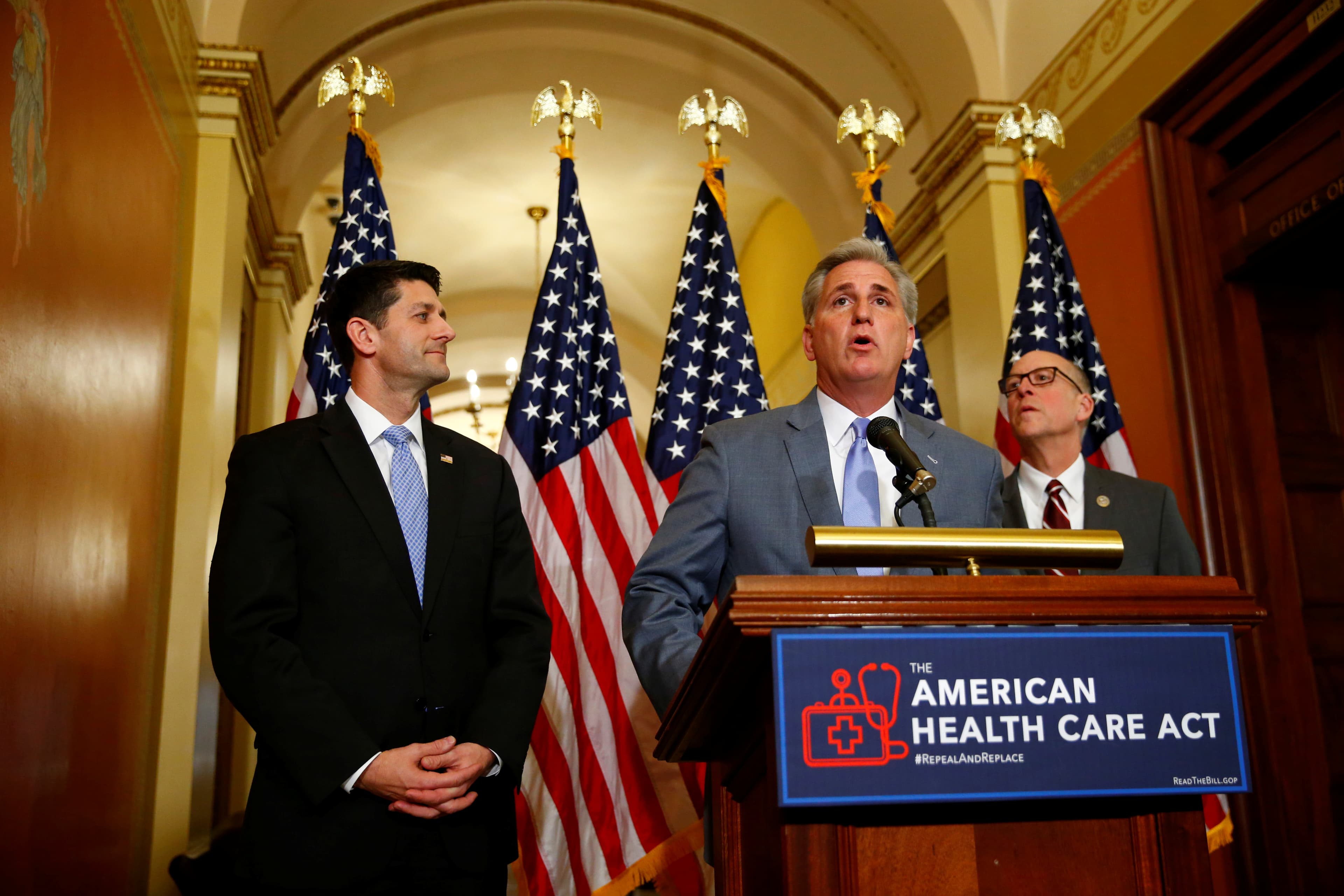 Three men standing at a podium