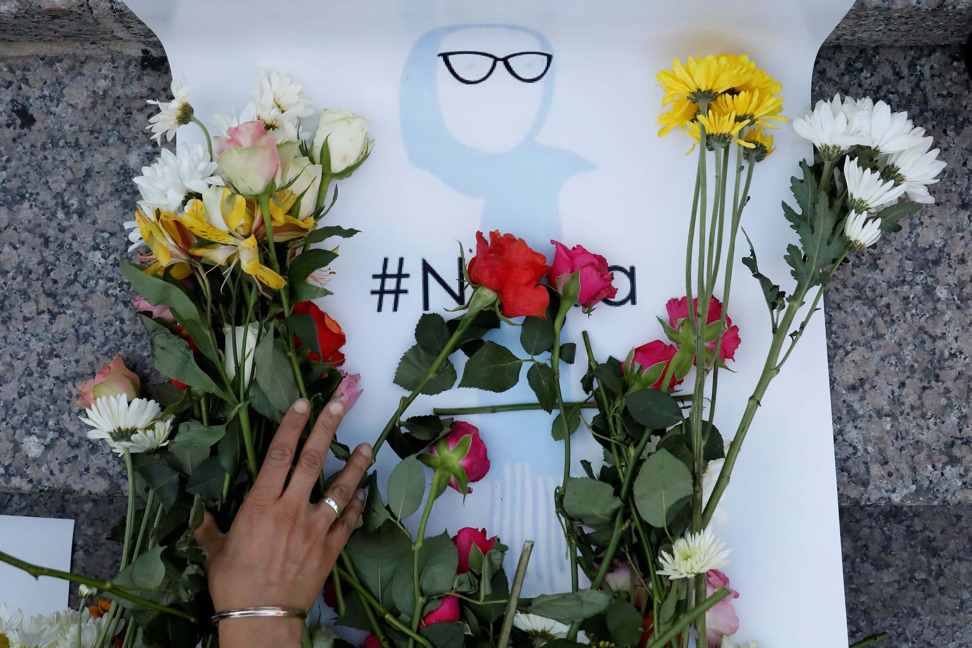 An attendee leaves flowers for Nabra Hassanen, a teenage Muslim girl killed by a bat-wielding motorist near a Virginia mosque, during a vigil in New York City, U.S. June 20, 2017.