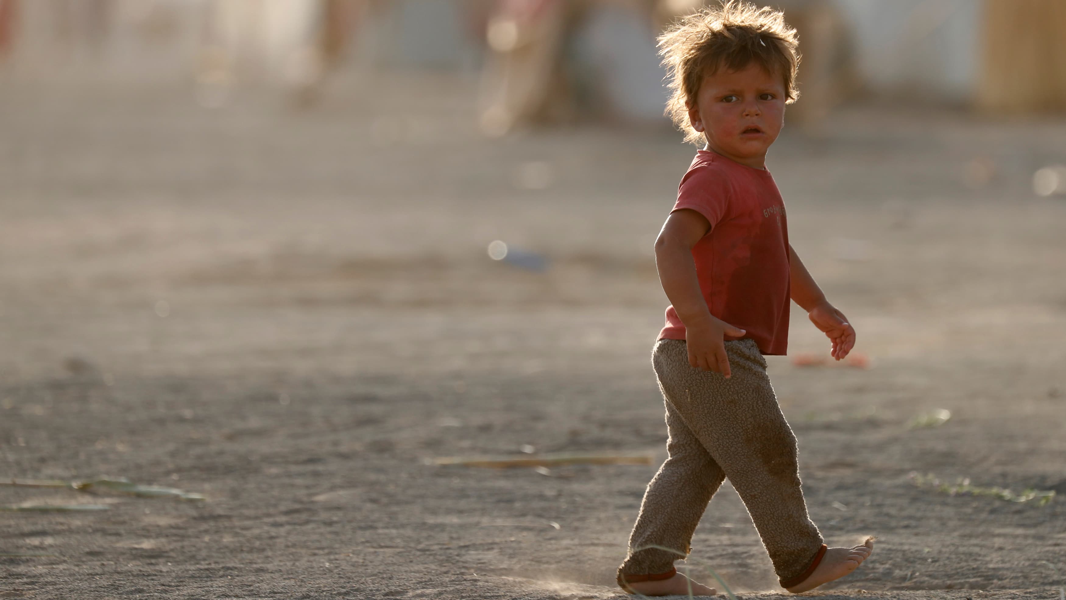 A boy, displaced from fighting in the Islamic State stronghold of Raqqa, walks in the desert near the village of Karama, east of Raqqa, July 1st 2017