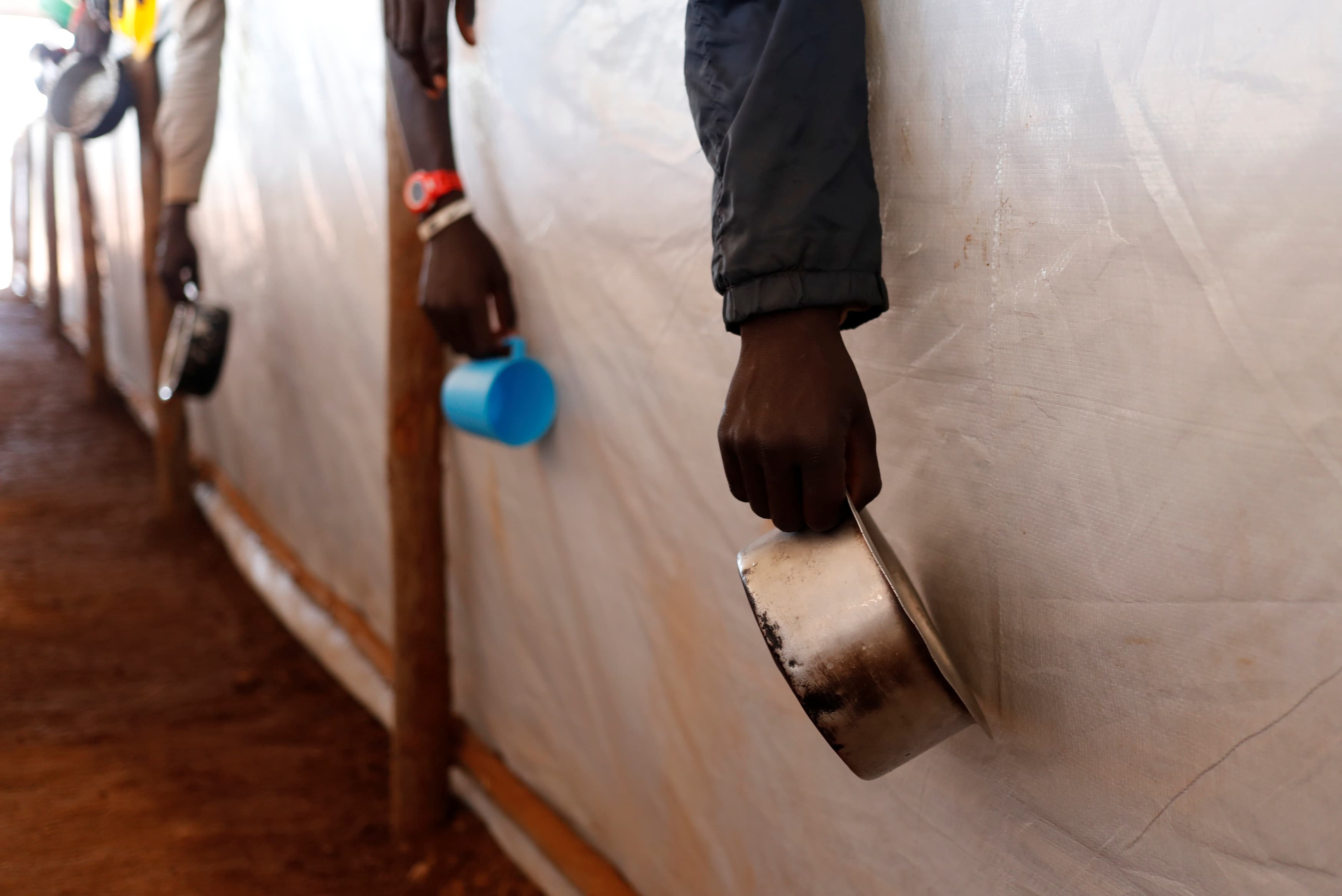 South Sudanese refugees wait in line for food in Omugo refugee settlement camp in northern Uganda