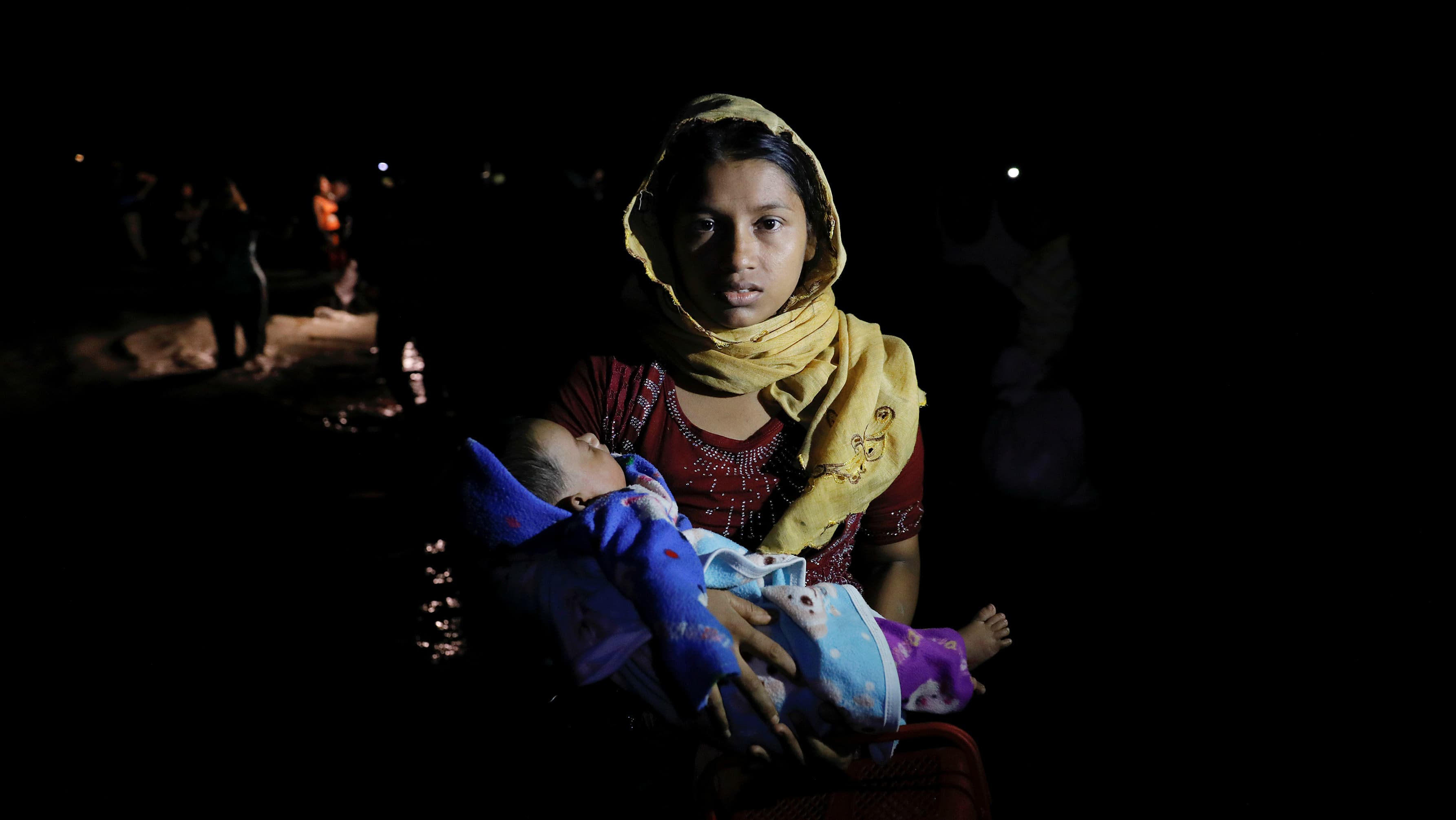 Rohingya refugees arrive under the cover of darkness by wooden boats from Myanmar to the shore of Shah Porir Dwip, in Teknaf, near Cox's Bazar in Bangladesh, Sept. 27, 2017.
