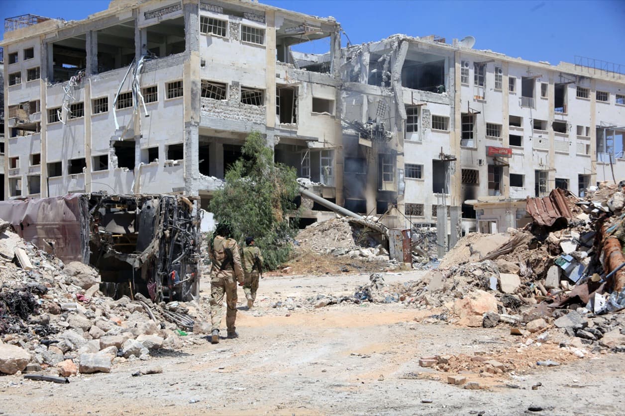 Forces loyal to Syrian President Bashar al-Assad walk past rubble after they advanced on the southern side of the Castello road in Aleppo, Syria.