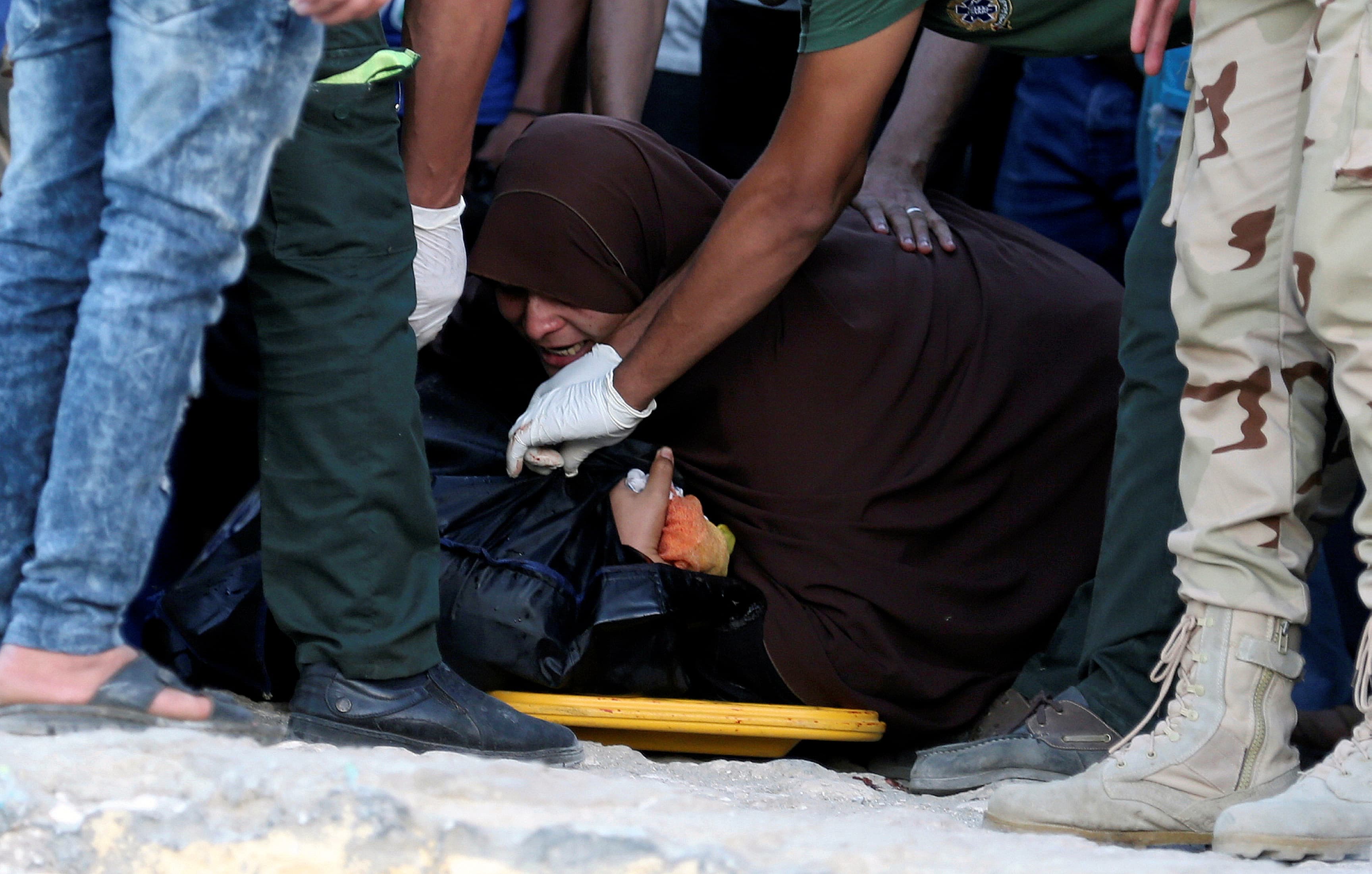 An Egyptian mother reacts beside the body of her son who was on a boat carrying migrants which capsized off Egypt's coast, in Al-Beheira, Egypt, September 22, 2016.
