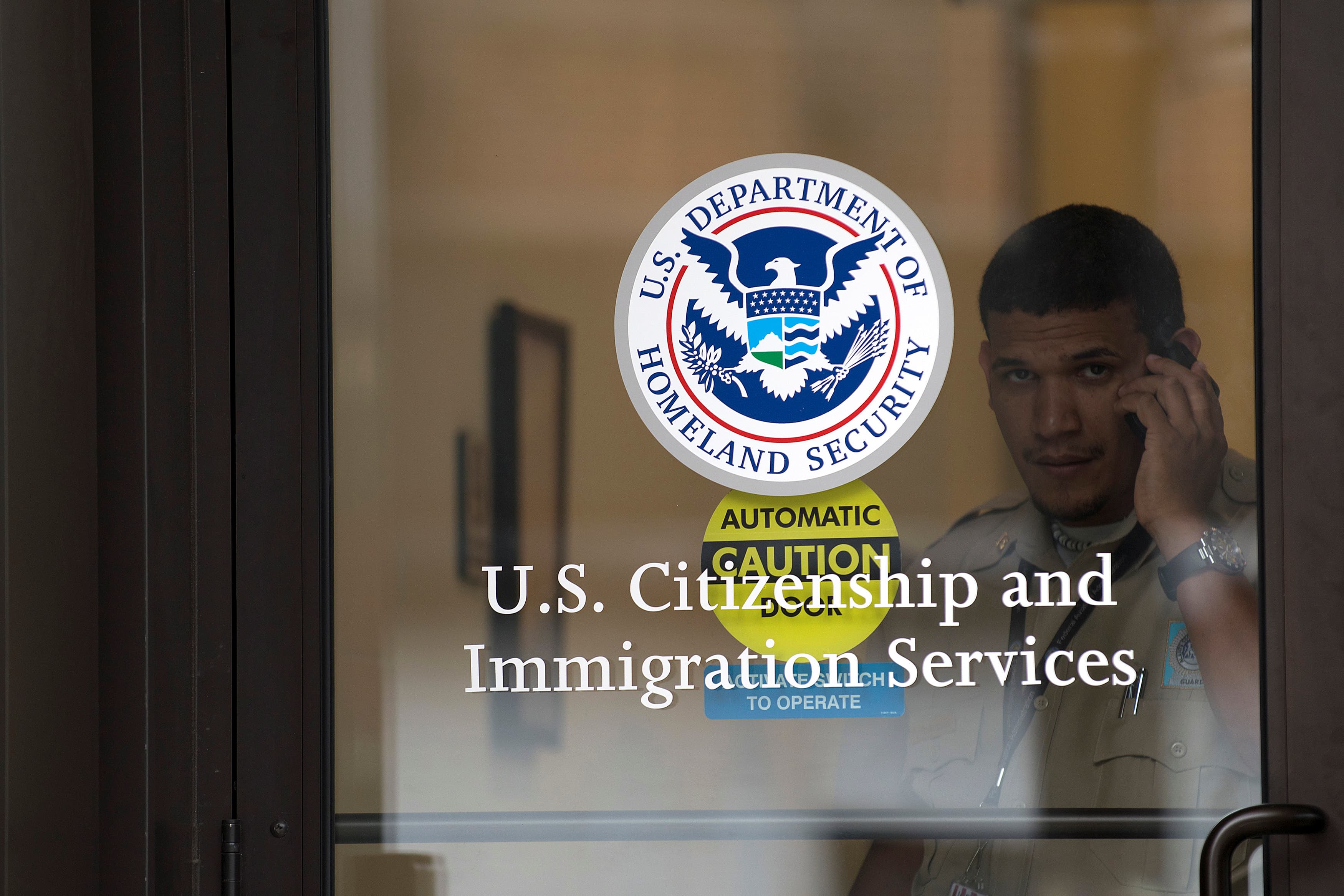 A security guard looks out of the U.S. Citizenship and Immigration Services offices in New York, U.S. on August 15, 2012.
