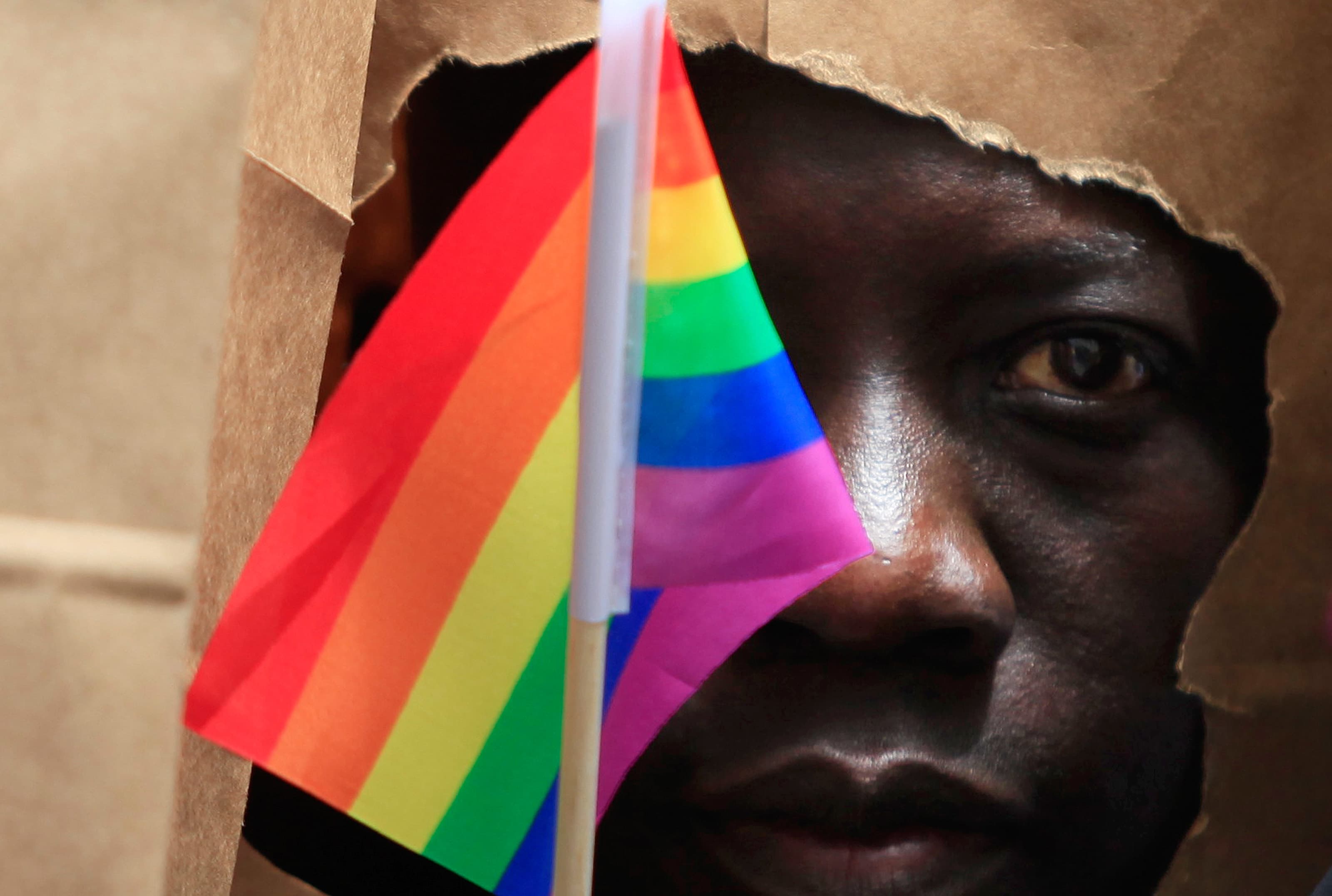 An asylum-seeker from Uganda covers his face with a paper bag in order to protect his identity as he marches with the LGBT Asylum Support Task Force during the Gay Pride Parade in Boston, Massachusetts, June 8, 2013.
