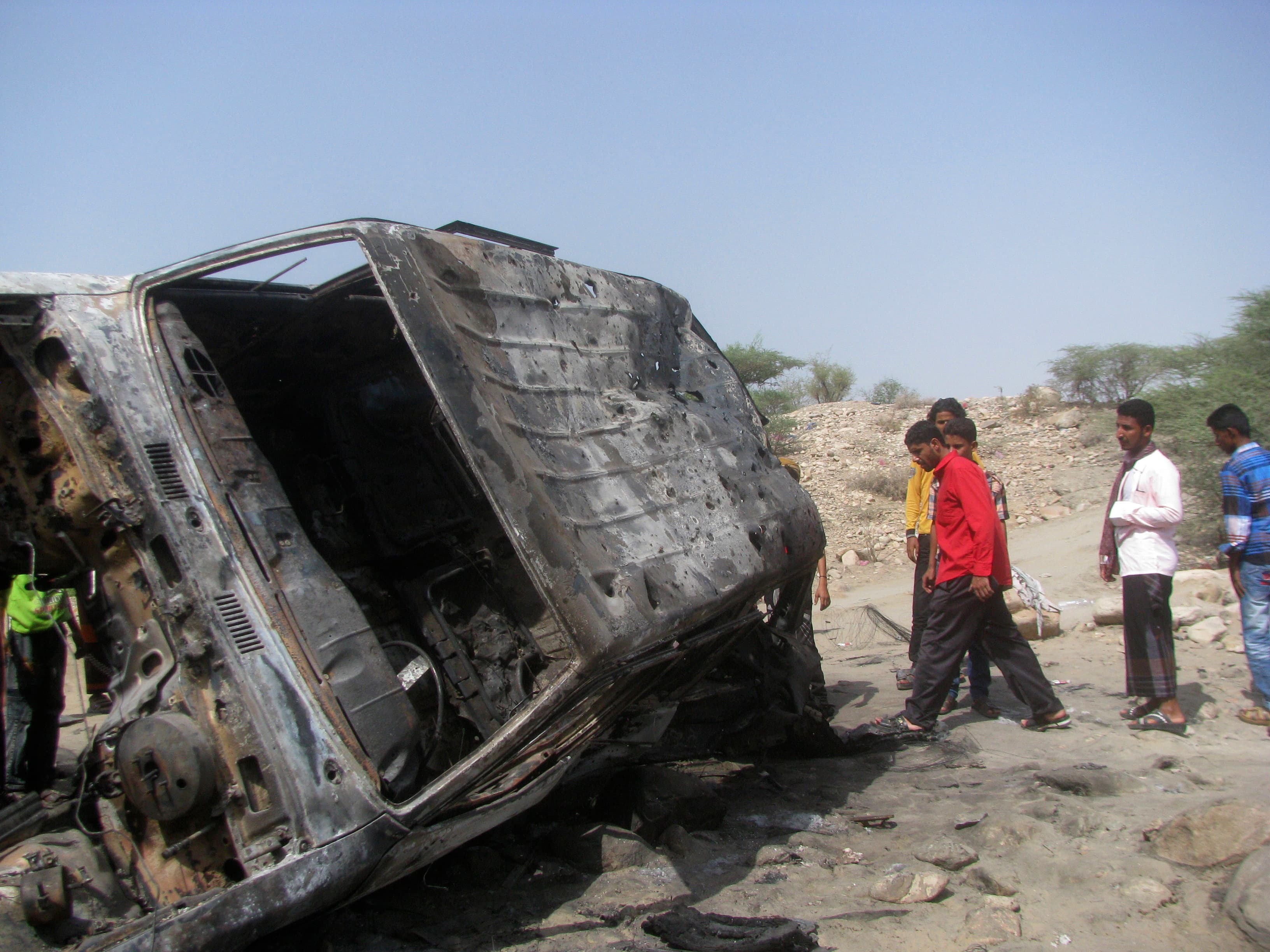 People gather at the site of a drone strike on the road between Yafe and Radfan districts of the southern Yemeni province of Lahj on August 11, 2013.