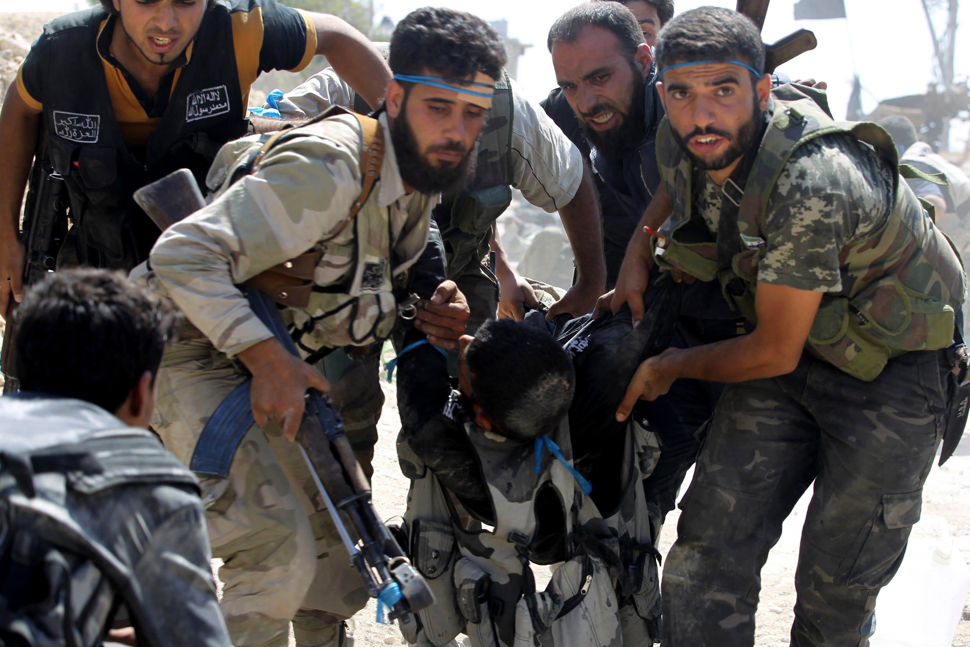 Free Syrian Army fighters carry a fellow fighter after he was wounded on the front line in Aleppo's Sheikh Saeed neighbourhood, September 21, 2013.