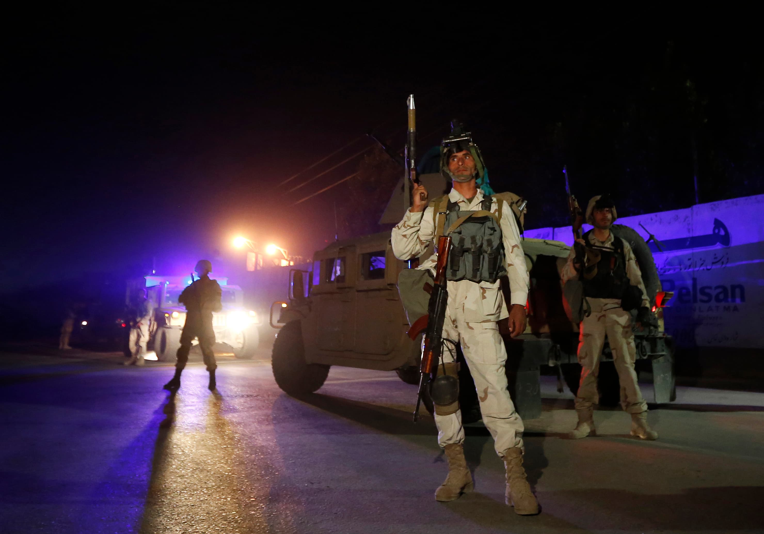 Afghan policemen keep watch at the site of an attack in Kabul.