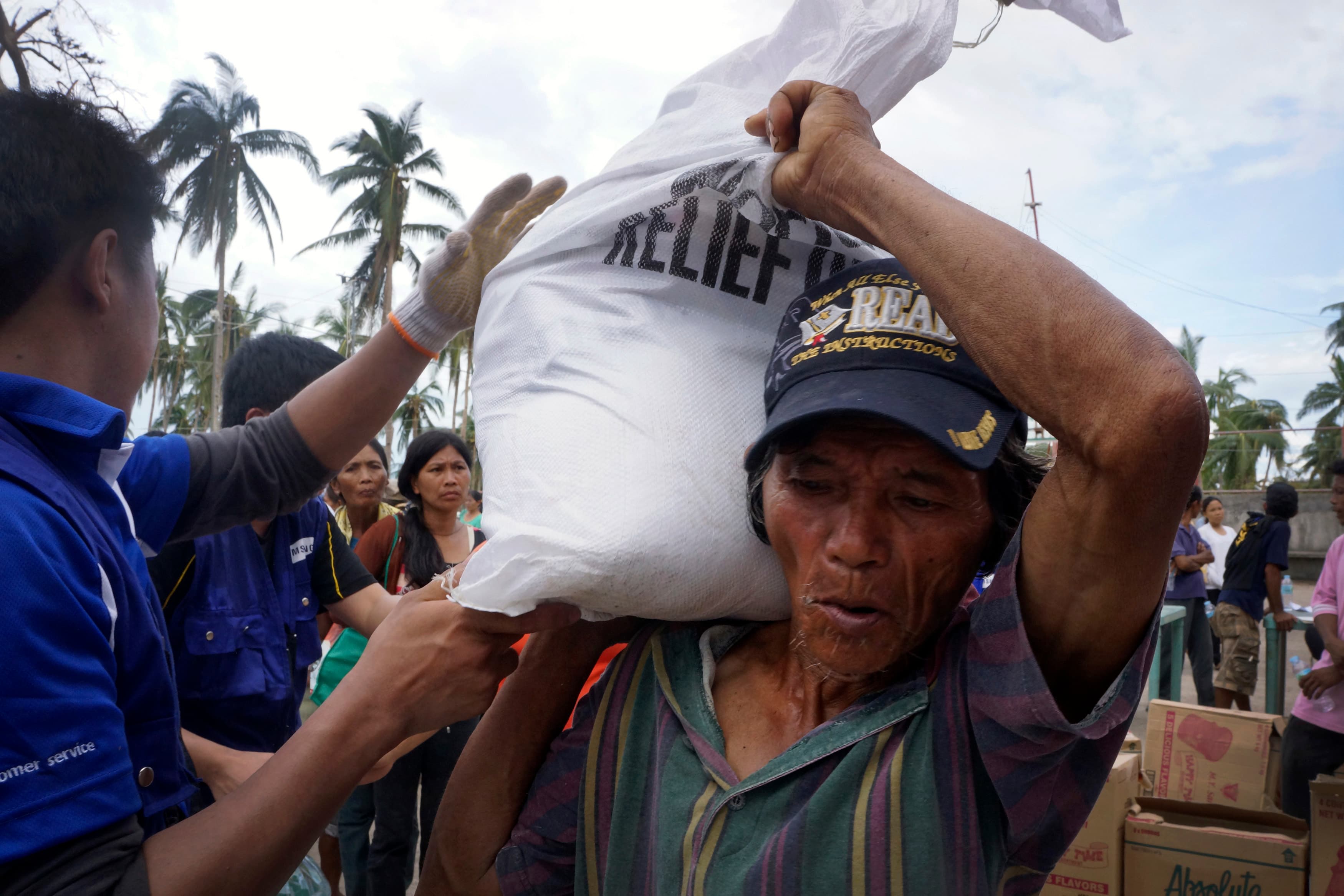 Locals line up for aid from international charity World Vision in Typhoon Haiyan damaged Tabogon district, in northern Cebu on November 14, 2013.