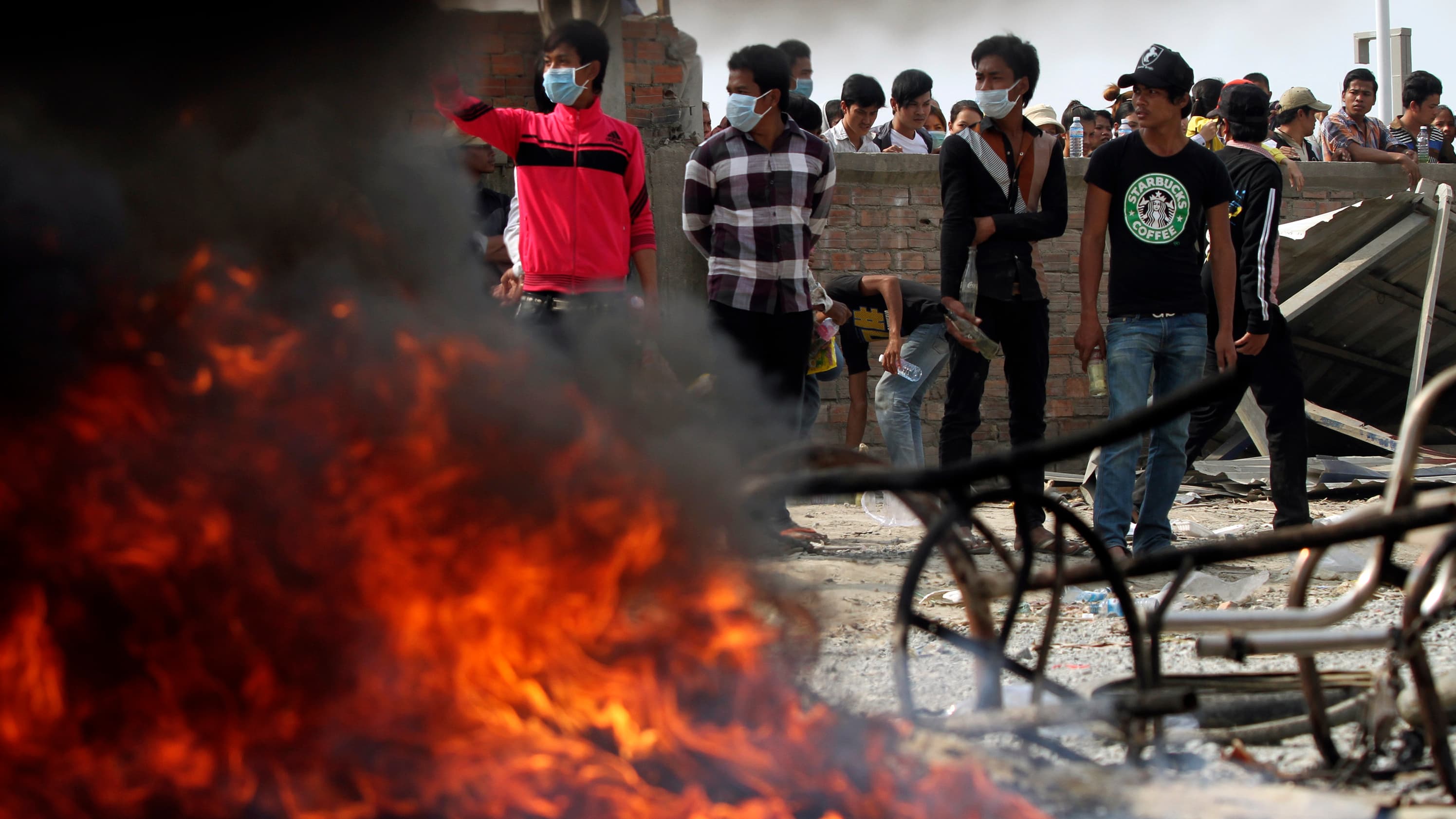 Garment workers holding Molotov cocktails after clashes broke out during a protest in Phnom Penh on January 3, 2014.