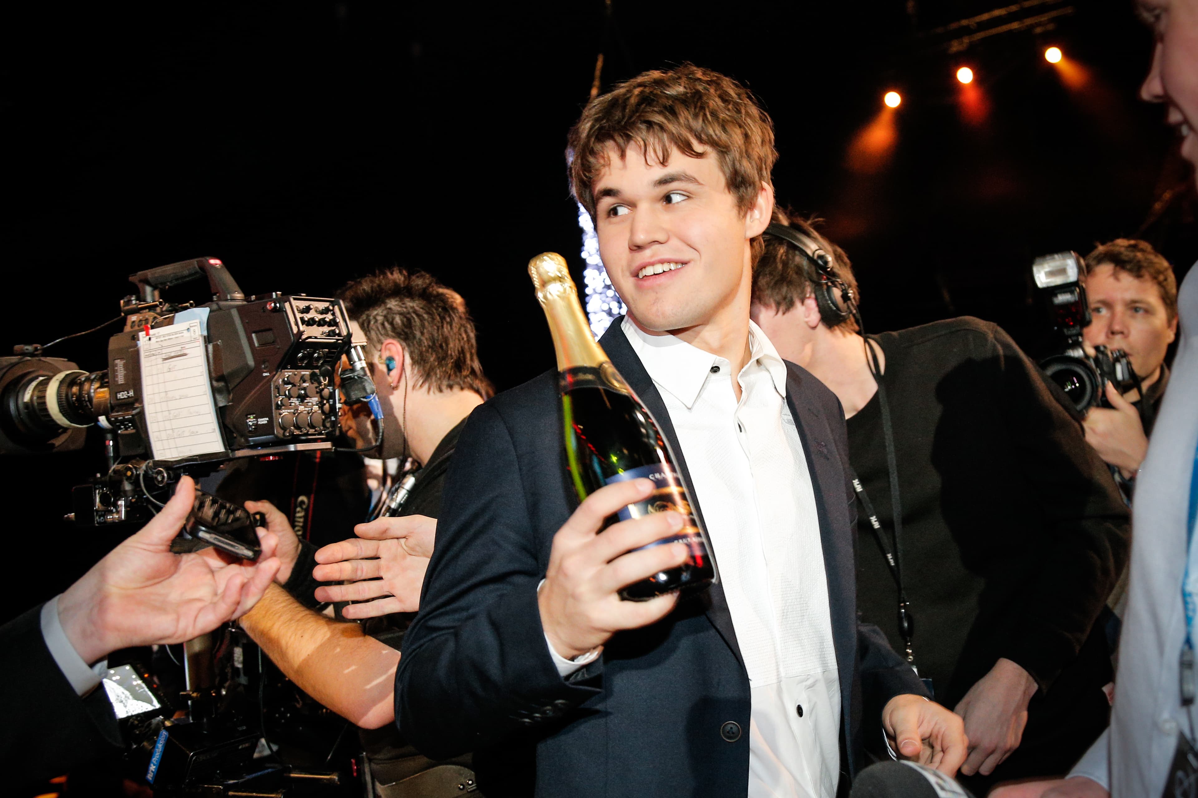 Norwegian chess world champion Magnus Carlsen in a suit and holding a bottle a Champagne  while attending the Norwegian Sports Gala in Oslo January 4, 2014.