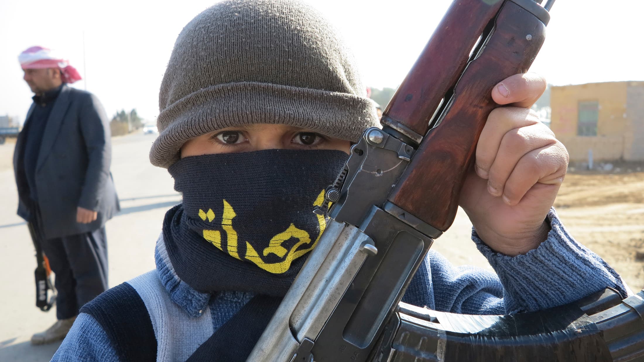 A boy holds up his Kalashnikov rifle on the streets of Ramadi, Monday. He's part of a tribal militia being raised to take part in the fighting between the Iraqi government and al-Qaeda linked militants. His militia appears to be on the government side at