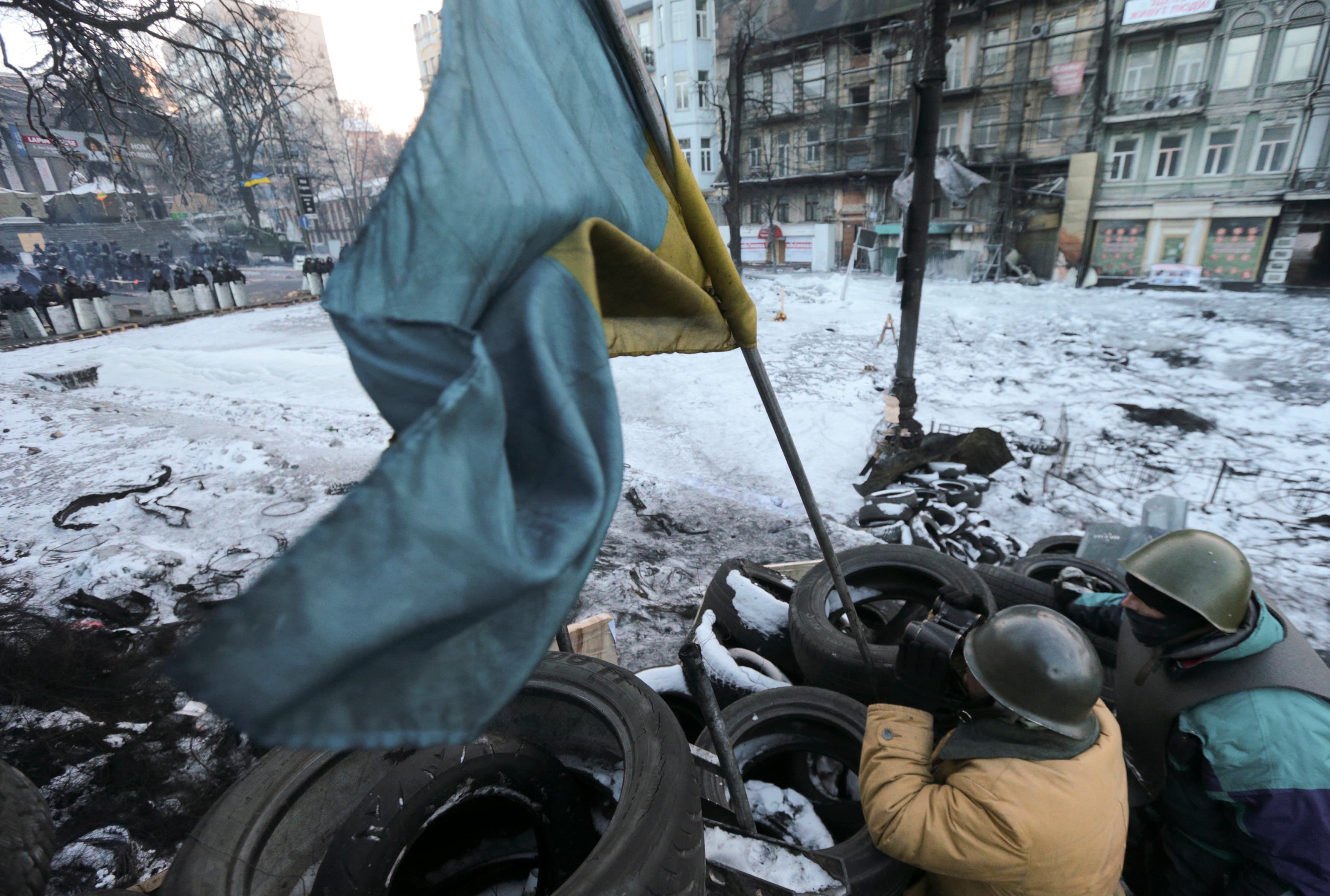 A demonstrator uses binoculars to keep an eye on security forces in the Ukrainian capital Kiev.
