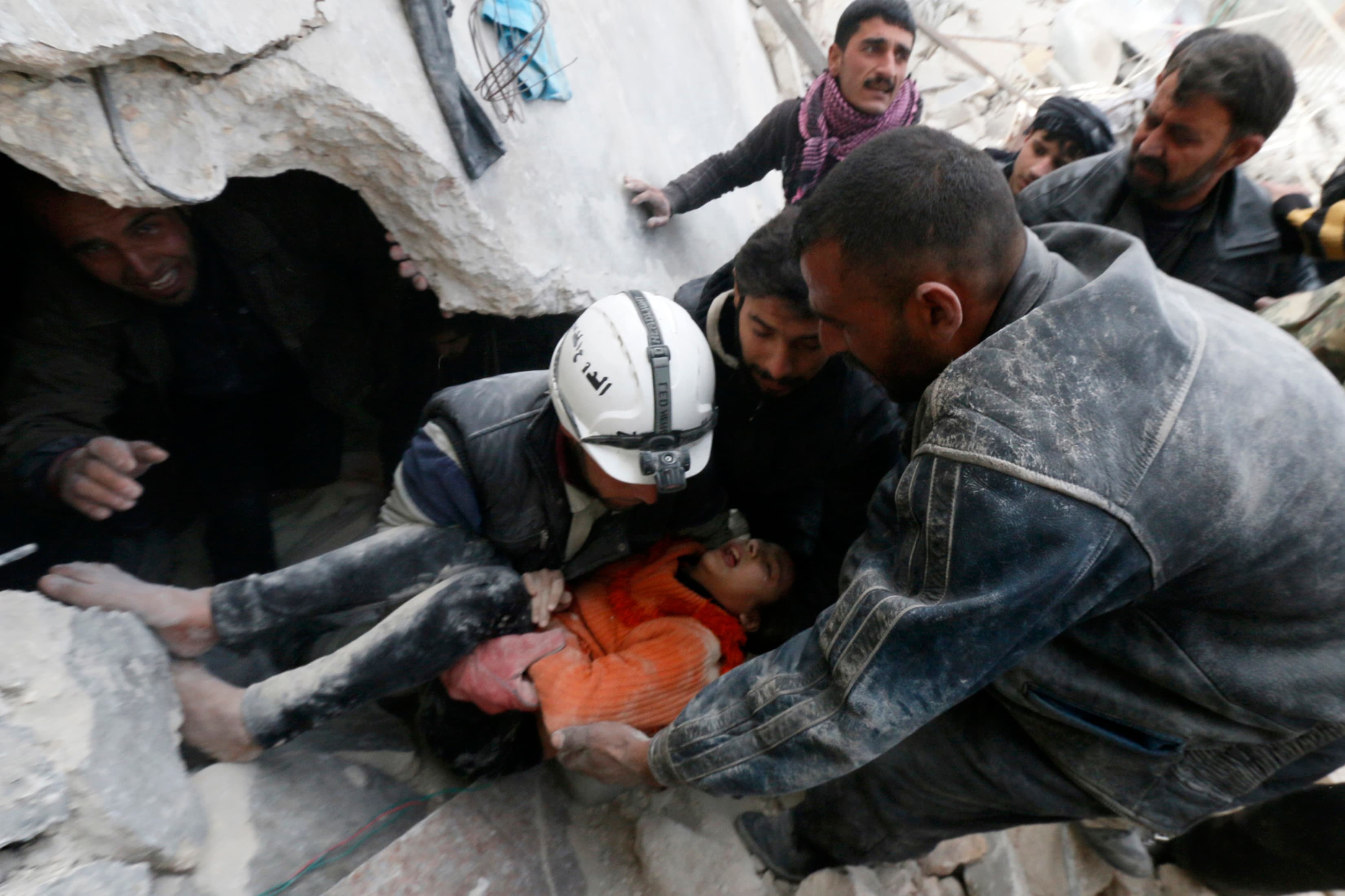 Residents and activists pull a girl from under debris after what activists said were explosive barrels dropped by forces loyal to Syria's President Bashar al-Assad in Aleppo, Syria on February 2, 2014.