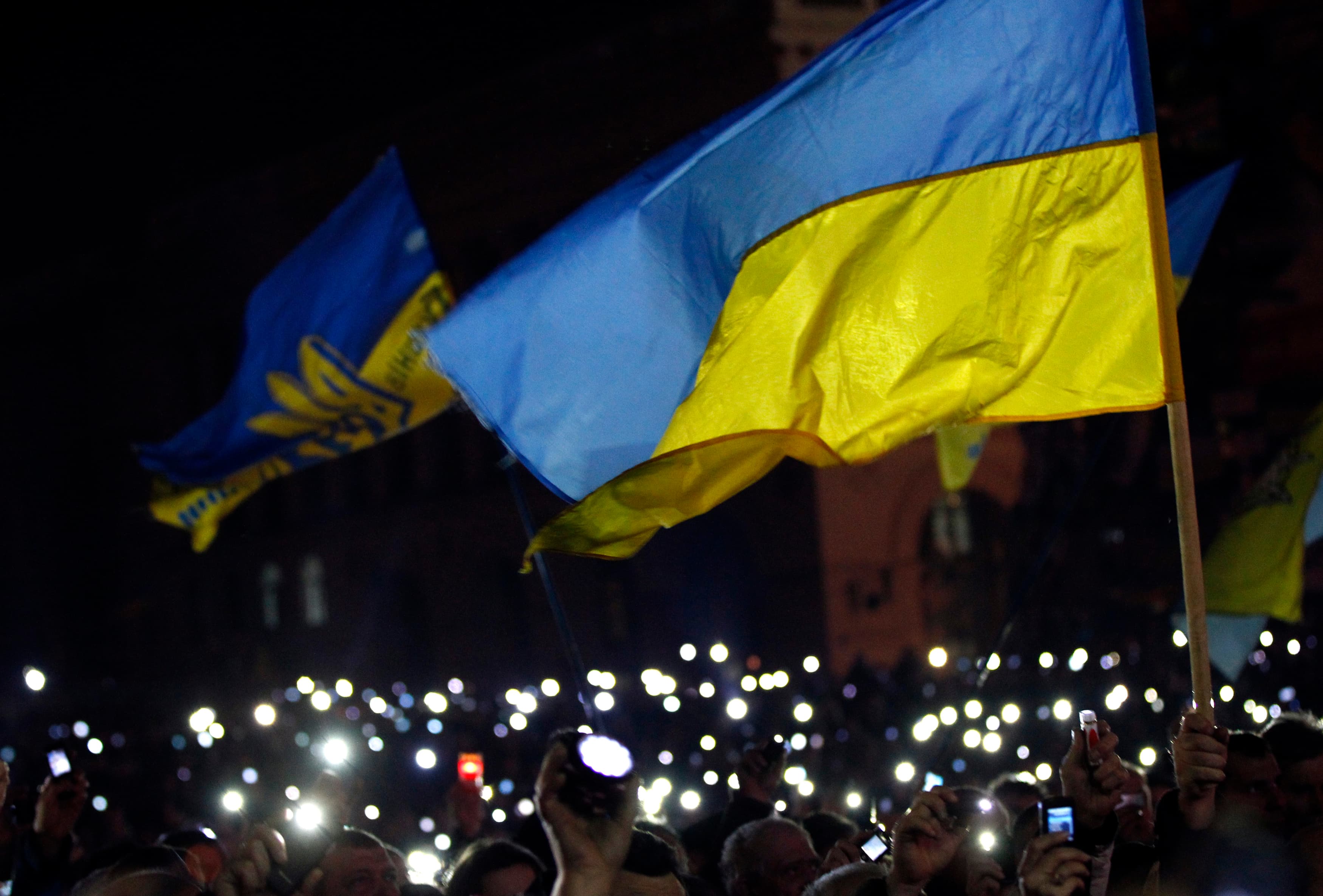 Anti-government protesters light torches and mobile devices in Kiev's central Independence Square. The protesters refuse to leave the streets, despite a deal between political leaders.