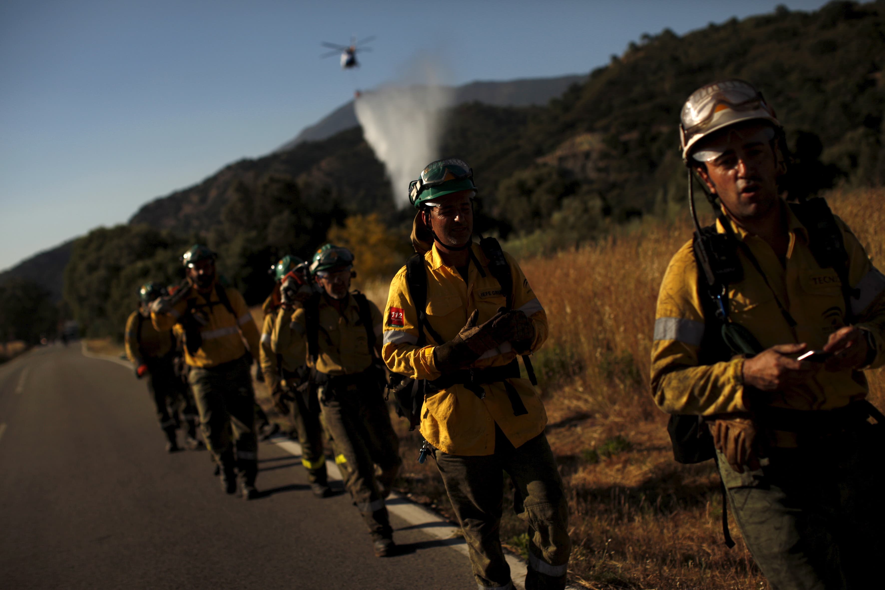 firefighters walk along a road