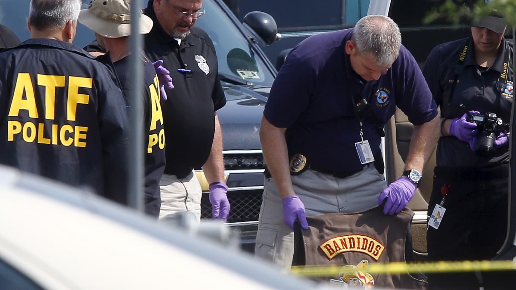 A police officer removes a jacket bearing the name of the Bandidos motorcycle gang from a vehicle at the Twin Peaks restaurant in Waco, Texas, where nine members of a motorcycle gang were shot and killed on May 19, 2015.