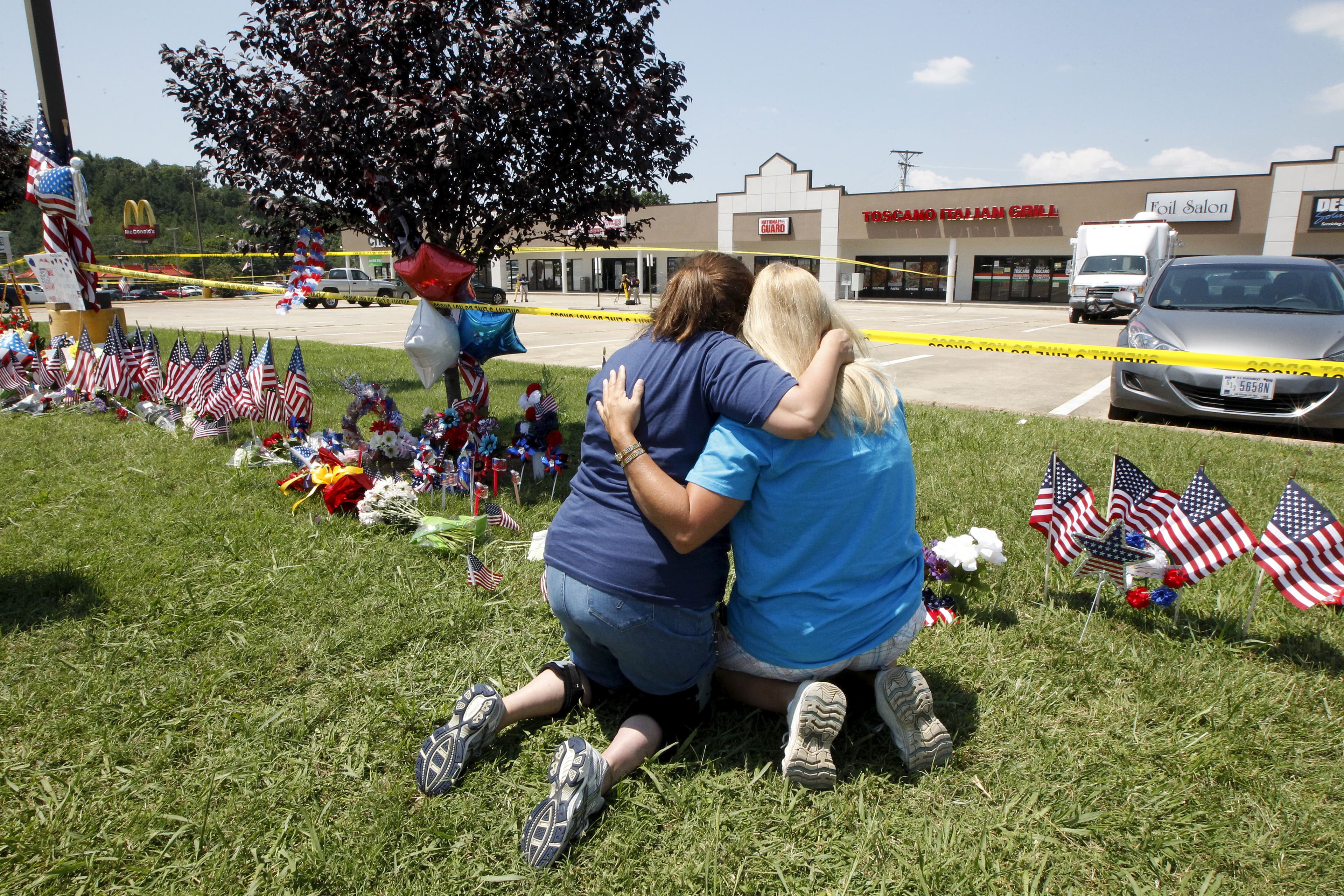 Betty Maynard (L) hugs her friend Cindy Atterton beside a growing memorial at the Armed Forces Career Center in Chattanooga, Tennessee July 17, 2015. Four U.S. Marines were killed on Thursday by a suspected gunman the FBI has confirmed as Mohammod Youssuf