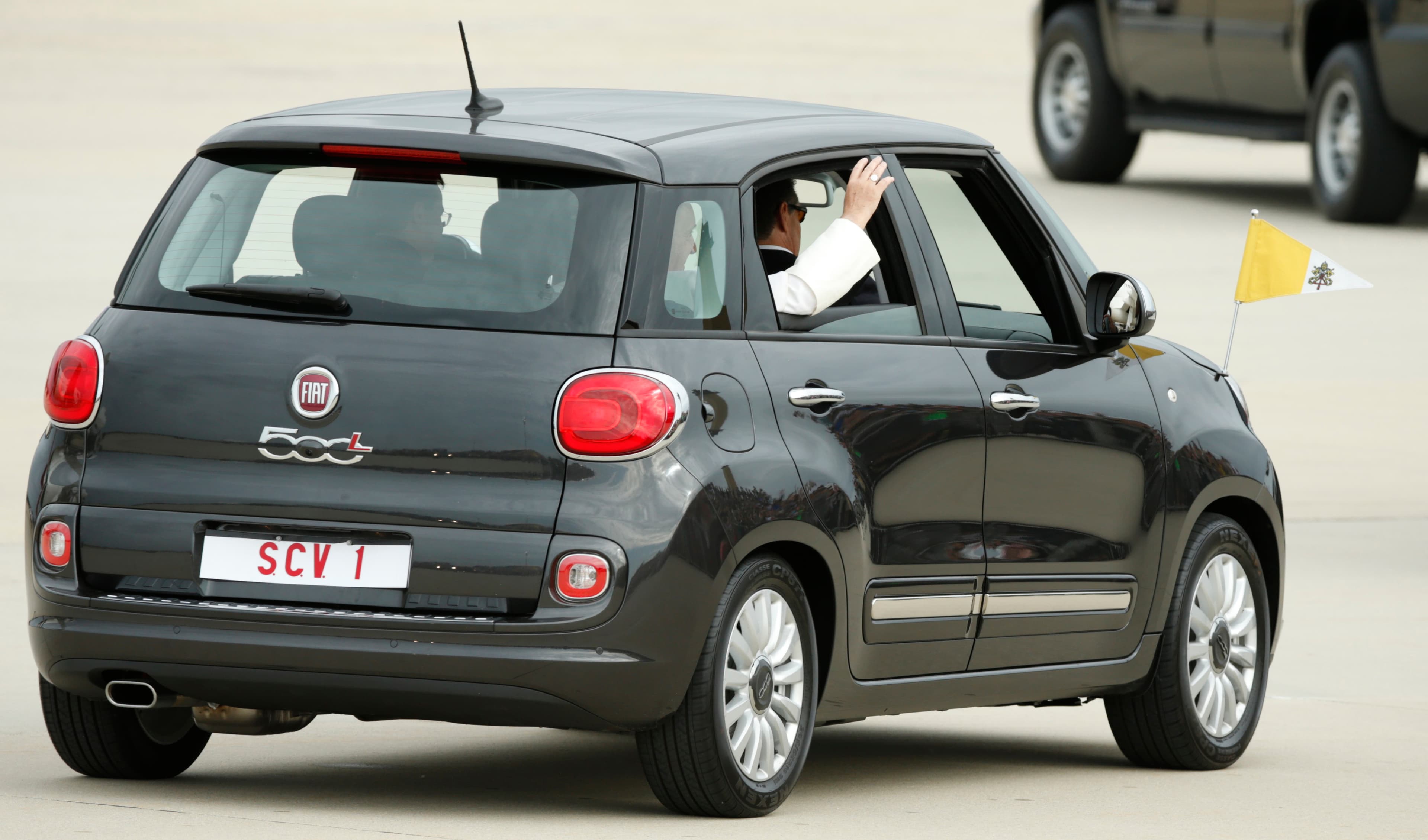 Pope Francis waves as he departs Joint Base Andrews, Maryland, in a Fiat 500 after arriving for his first trip to the United States.